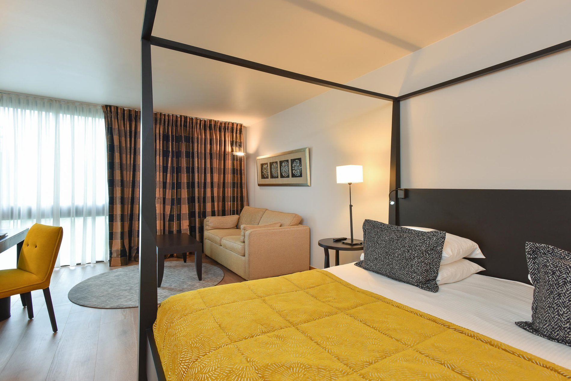 Great Lake View Zimmer mit King-Size-Bett, gelber Bettdecke und großen Fenstern im Martin's Château du Lac.