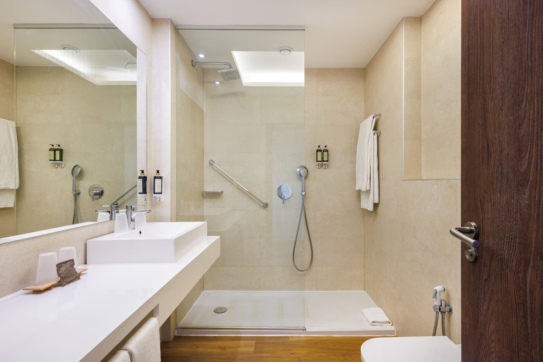 Salle de bain spacieuse de la chambre familiale Plus pour se détendre pendant des vacances en famille à l’Hôtel Jupiter Albufeira