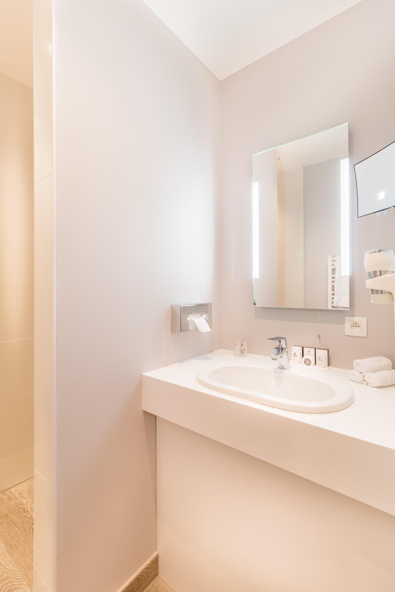 Modern bathroom at Martin's Red with a lighted mirror and stylish sink.