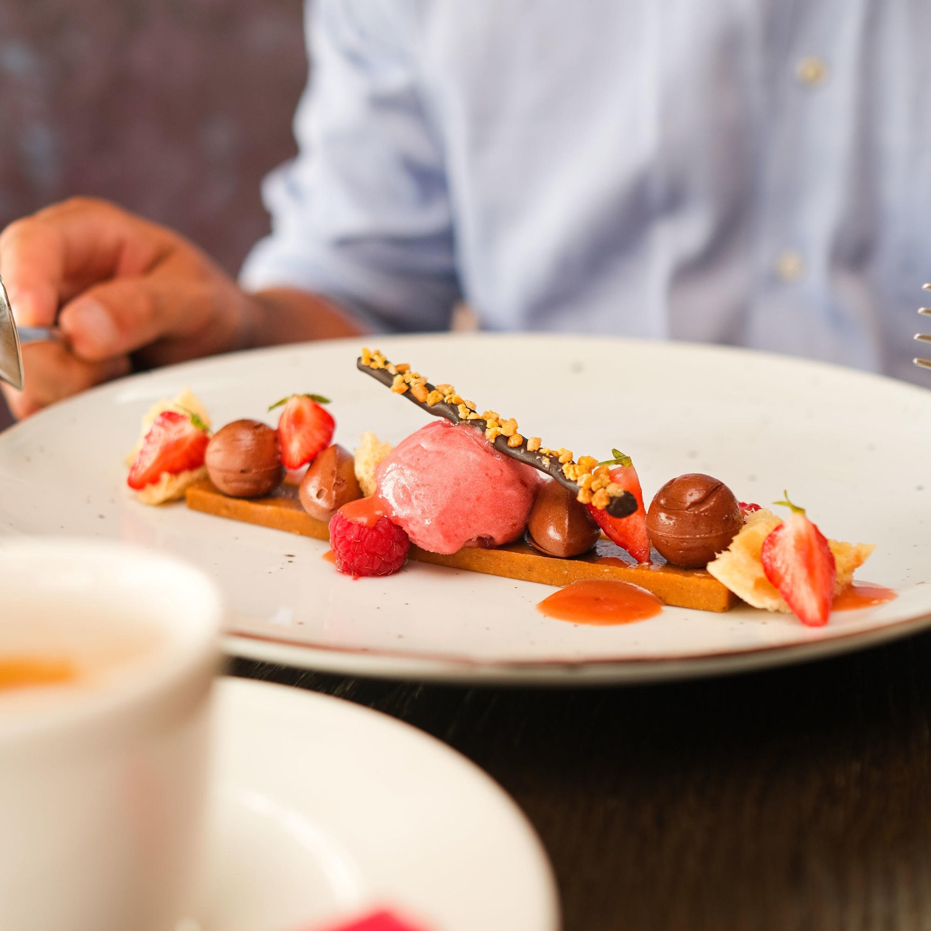 Close-up of a dessert plate garnished with fruits and decorative elements.