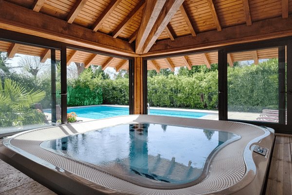 Jacuzzi intérieur avec vue sur une piscine extérieure à Chenonceaux