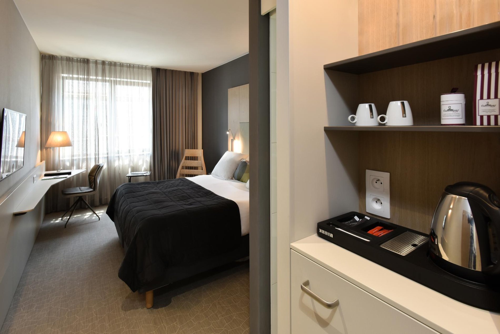 Kamer met tweepersoonsbed, bureau en gastvrijheidsplateau.