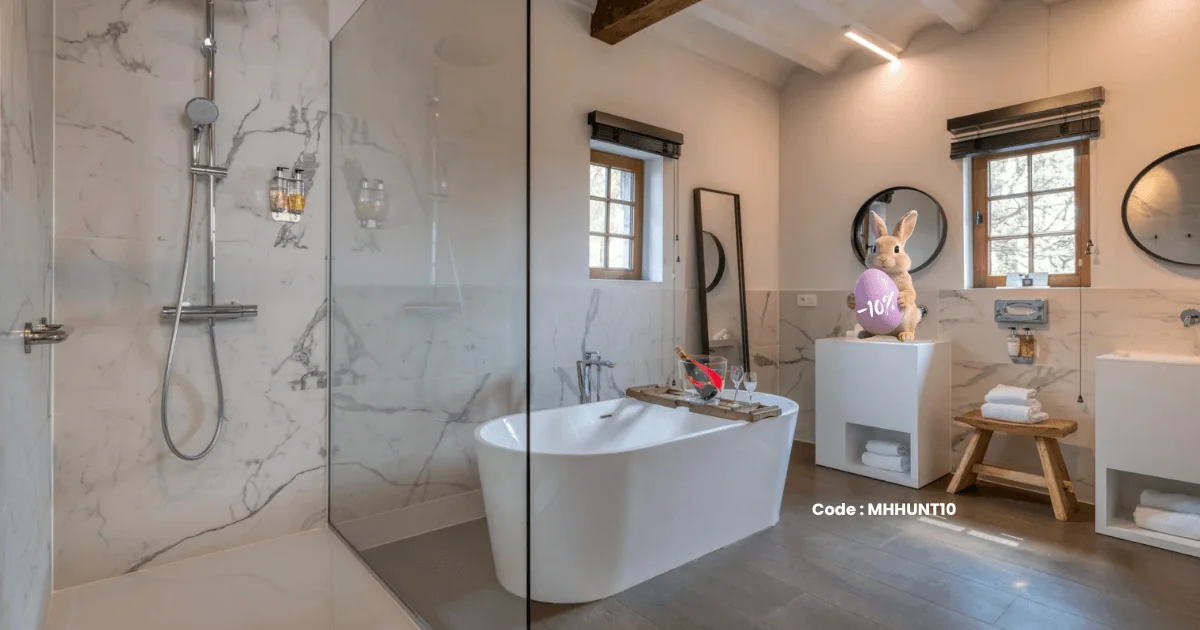 Salle de bain lumineuse avec baignoire et douche dans la suite Martin's Rentmeesterij, Bilzen.