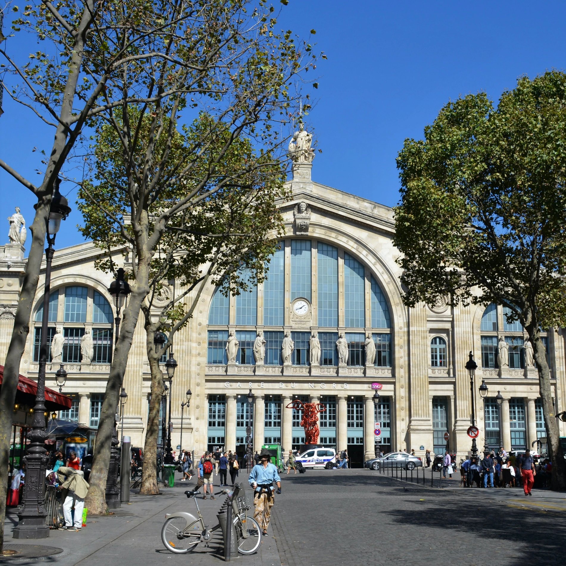 Façade de la Gare de l’Est à Paris avec passants et cyclistes