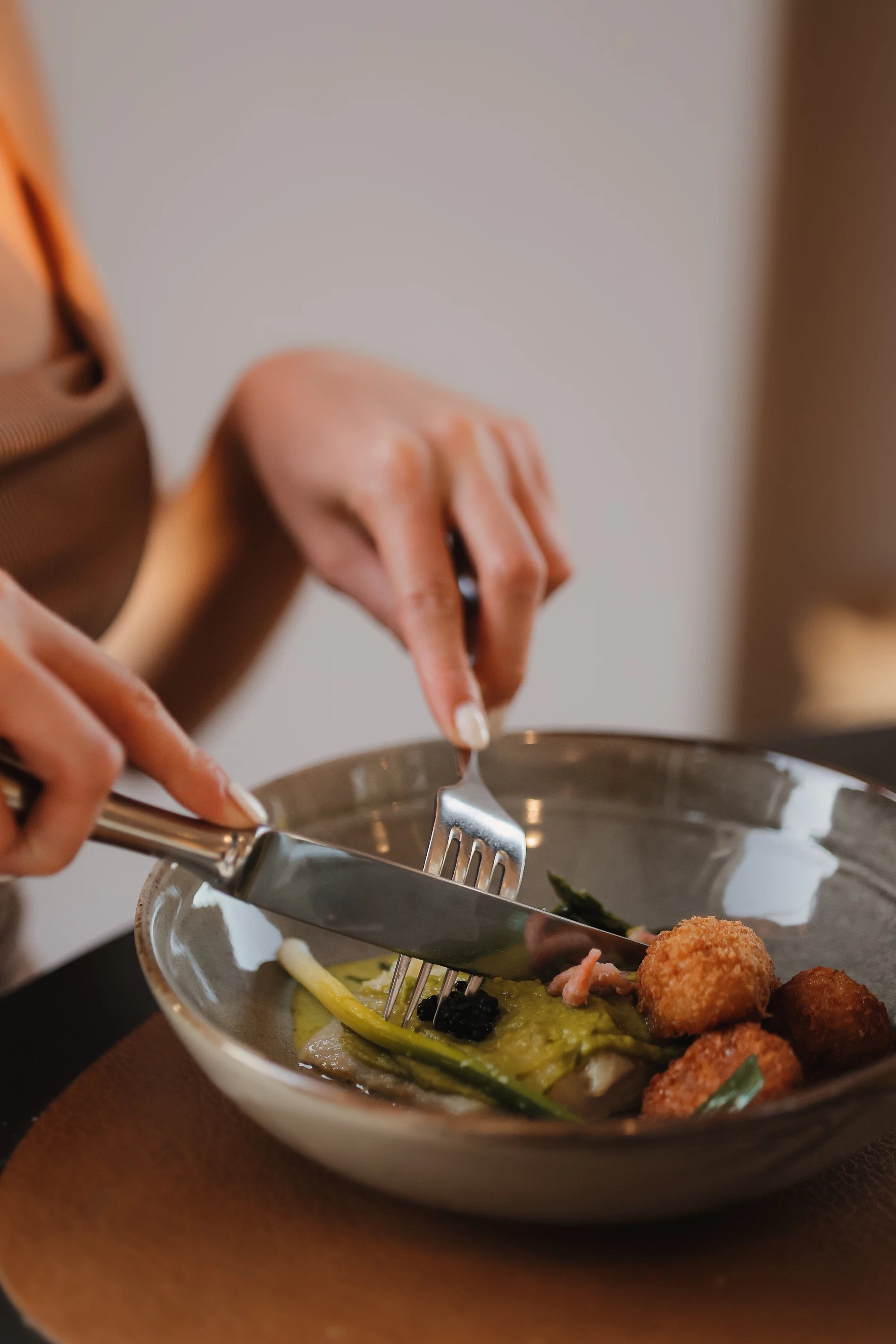Close-up of a person serving fresh salad into a plate.