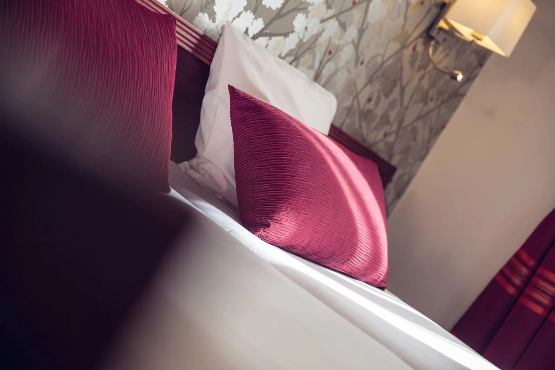 Détail de la décoration dans une chambre Confort au Timhotel, avec coussins rouges