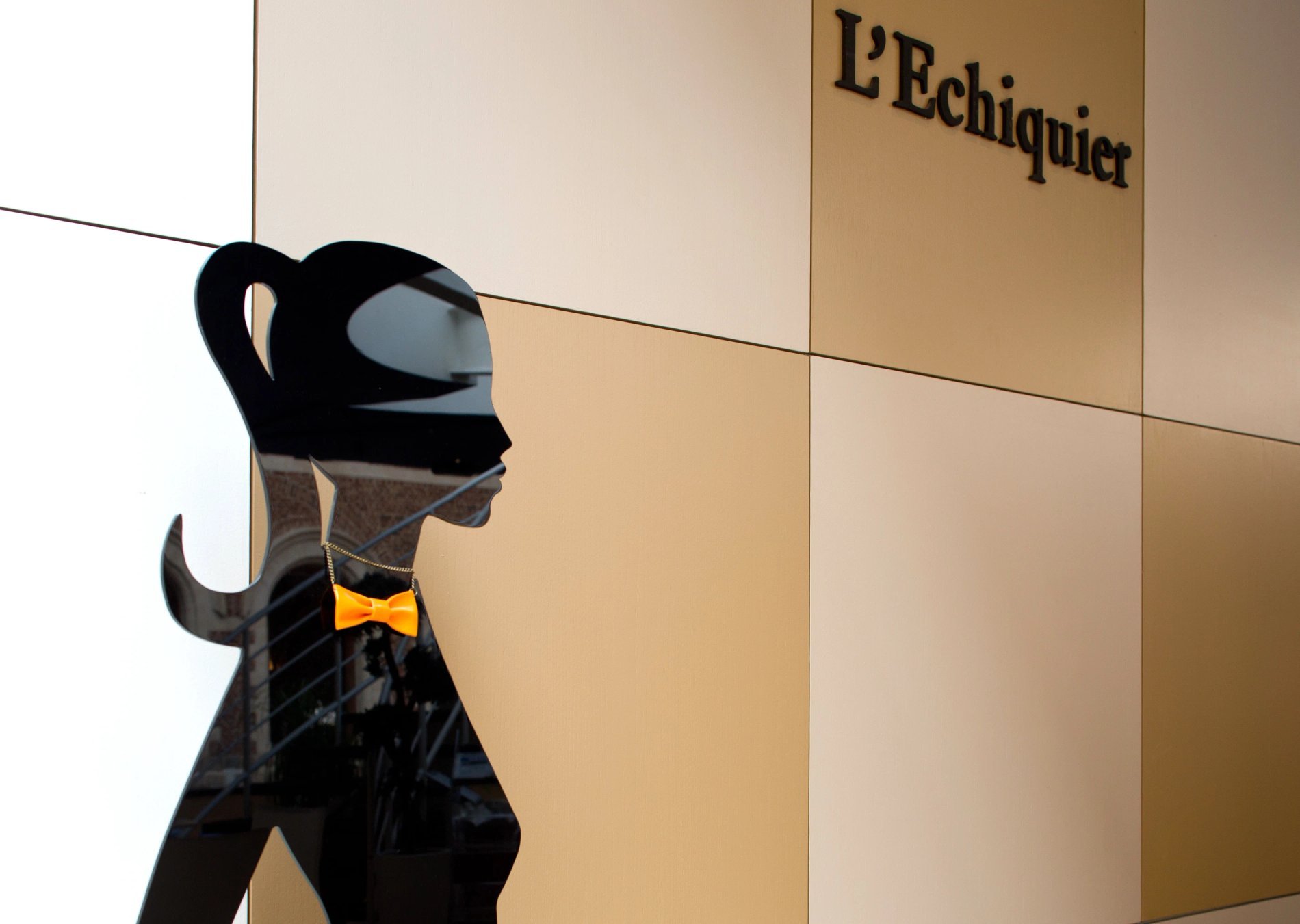 L'Echiquier, Chic bar Old Lille: elegant silhouette before the sign, reflecting the modern and sophisticated ambiance of Hotel Le Couvent des Minimes.