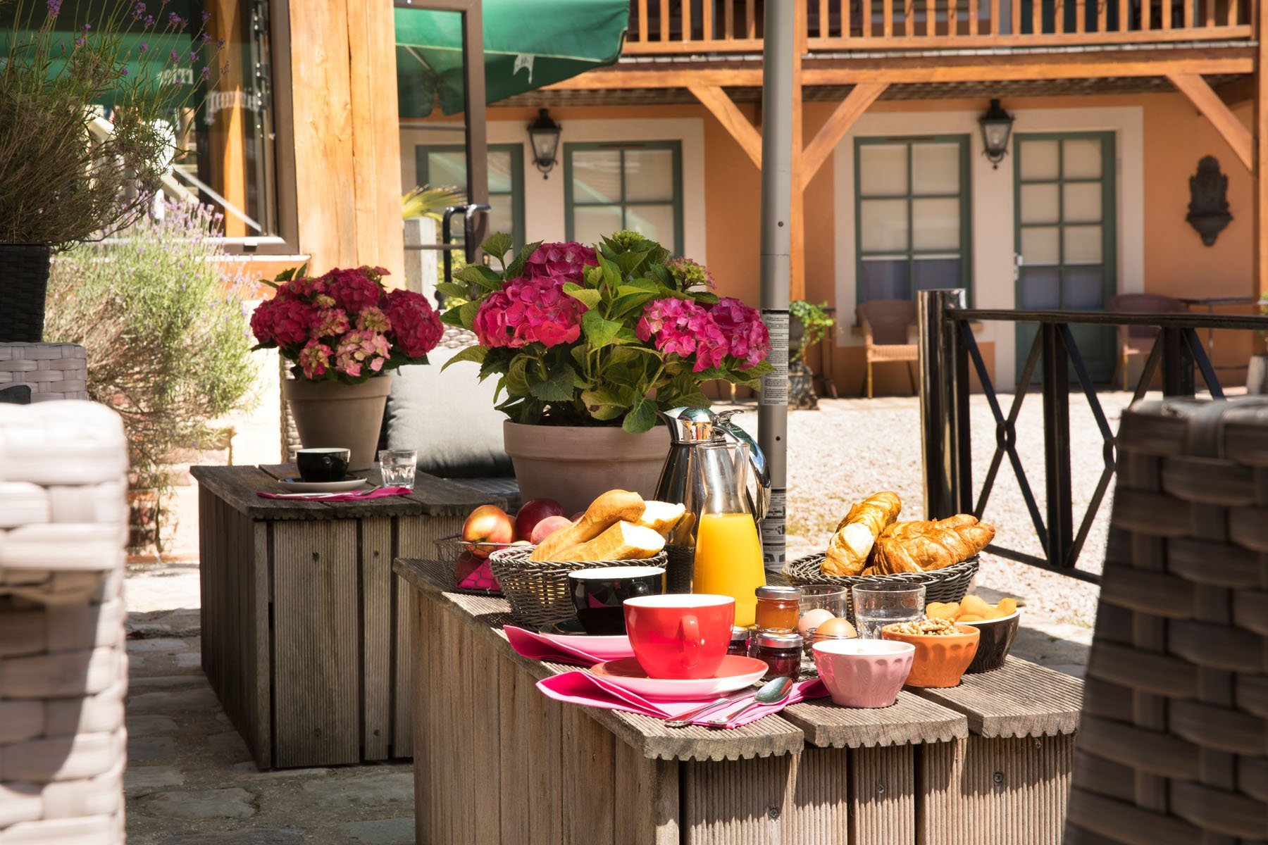 Terrasse accueillante du restaurant Ô Patio de l'Hôtel SPA Le Lion d'Or, aménagée pour le petit-déjeuner ou un repas en extérieur.