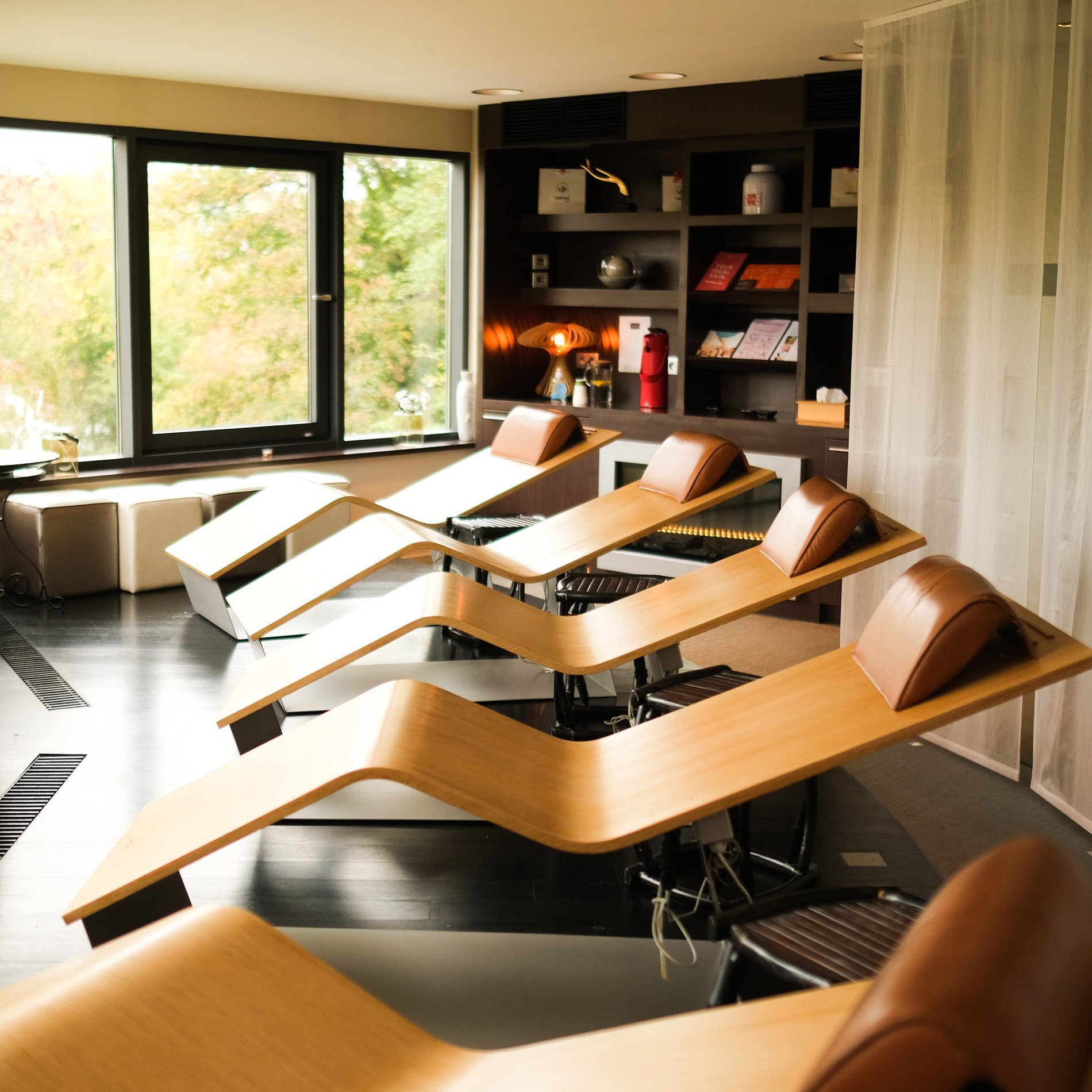 Ruheraum mit Holzliegen und großen Fenstern mit Blick auf die Natur.