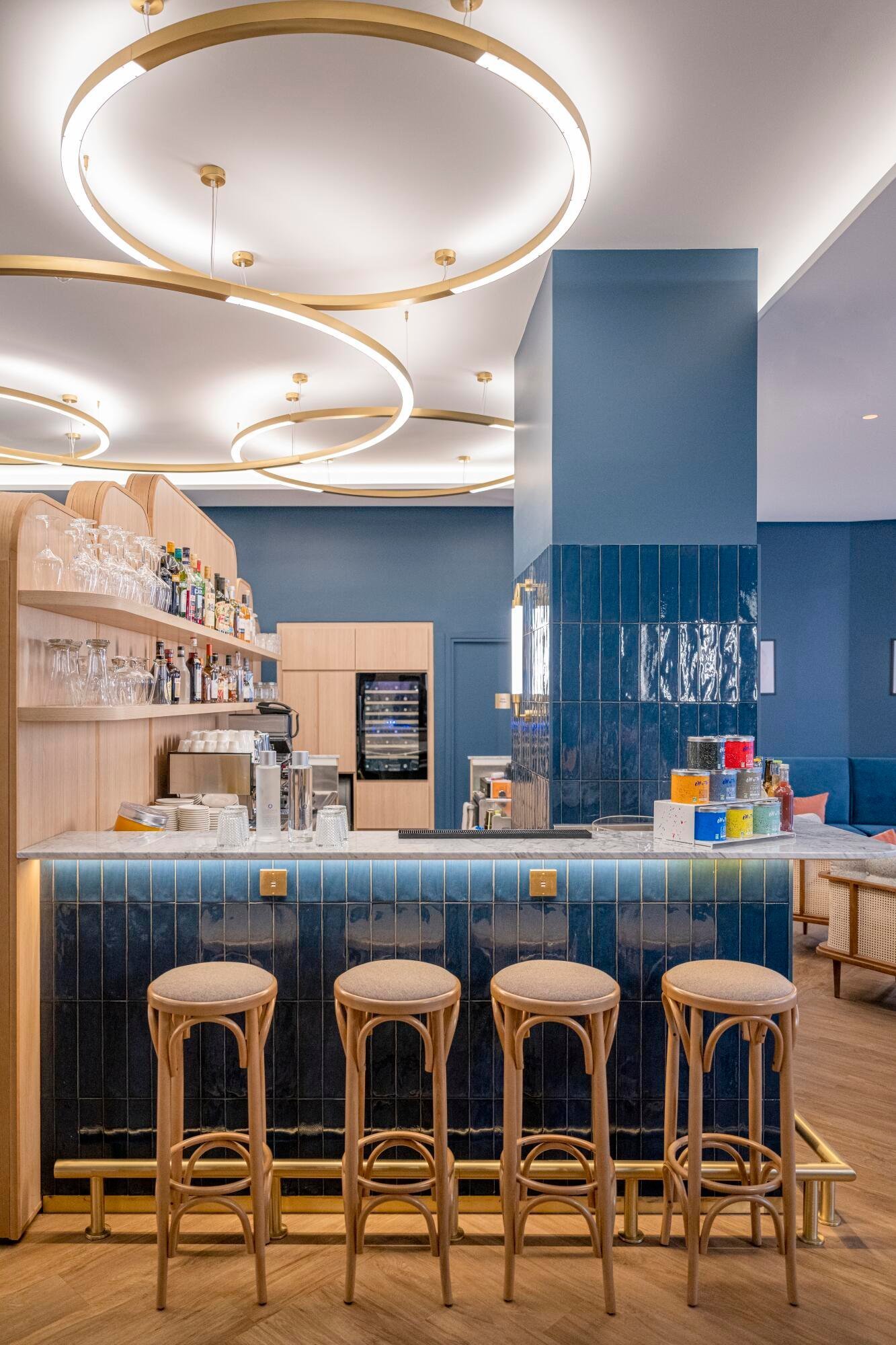 Modern interior of the bar-restaurant at VOCO Paris Montparnasse with high stools and stylish lighting.
