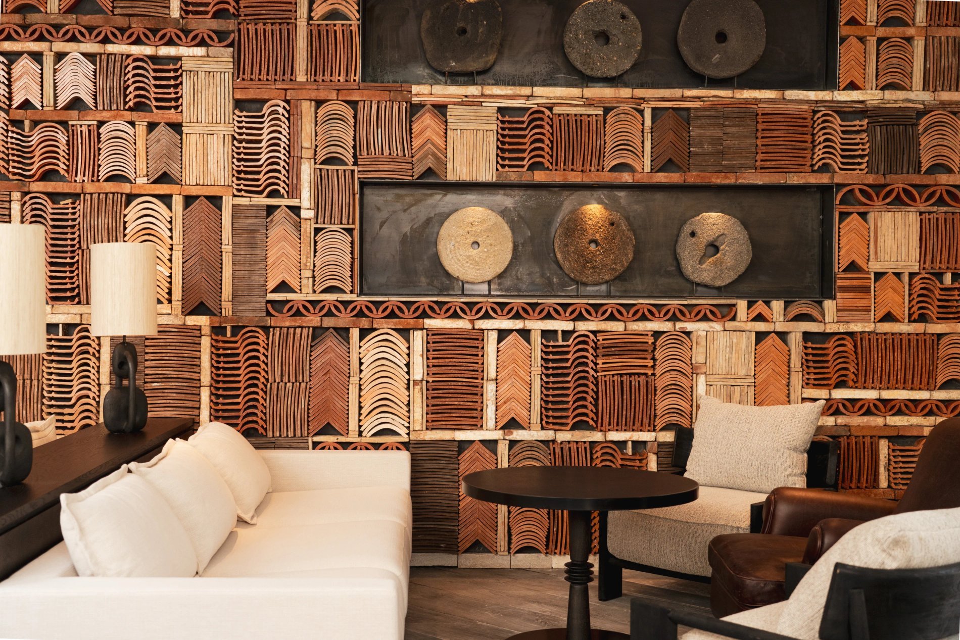 Salon cosy avec mur en tuiles décoratives et assises confortables à L’Isle de Leos.