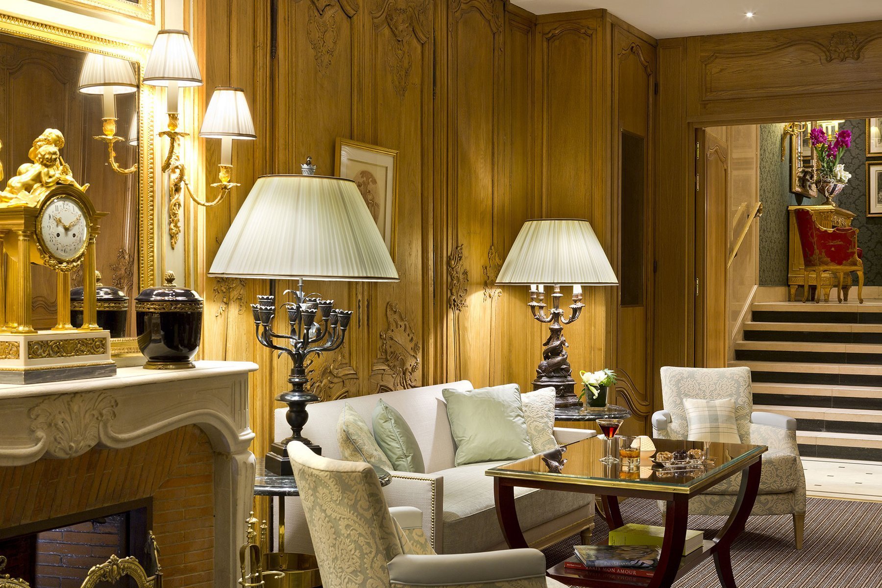 Lounge with noble wood panelling at Hôtel San Régis, classic decor and cozy ambiance.
