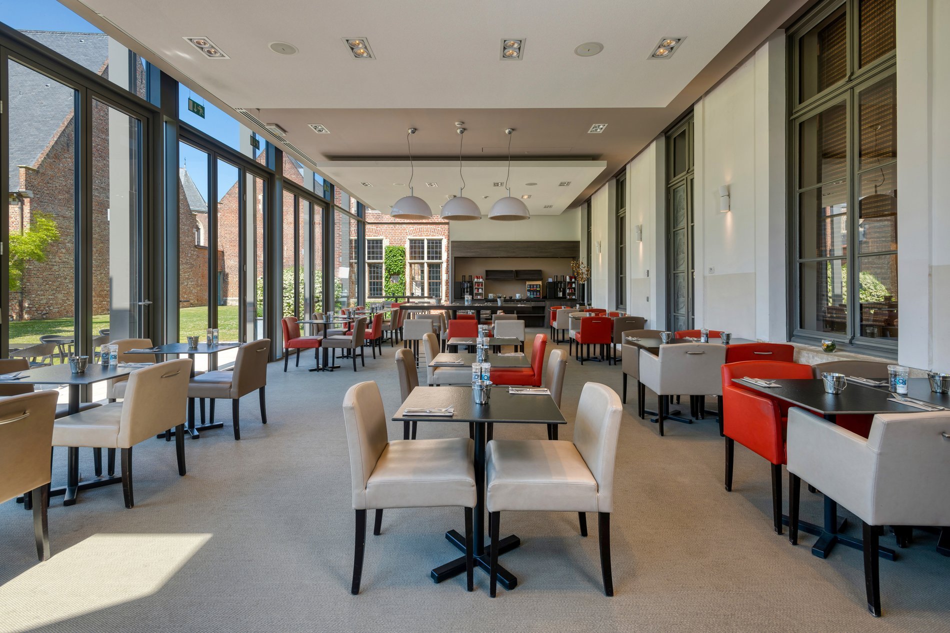 Lichte lounge met grote ramen in het Martin's Klooster in Leuven.