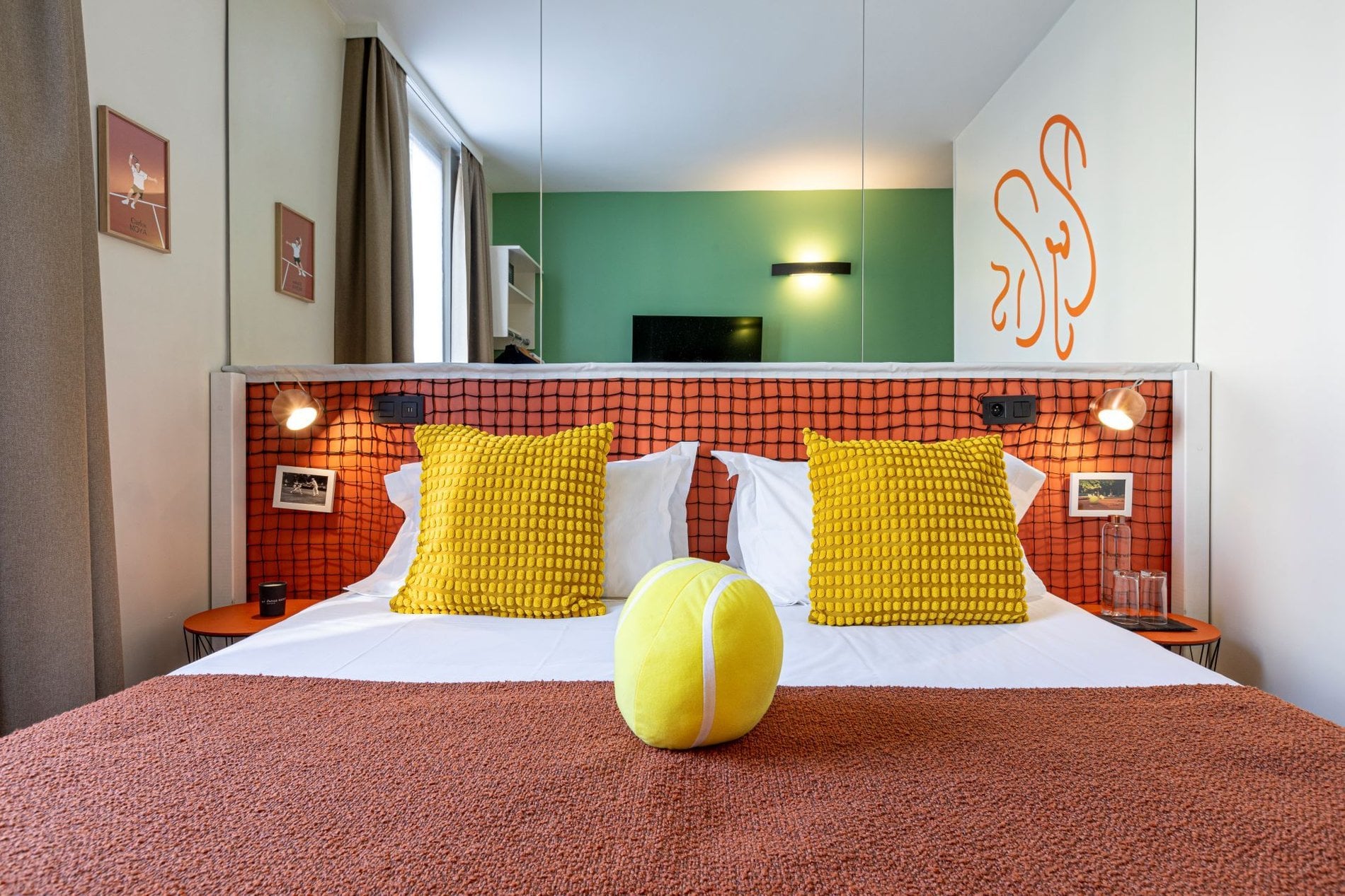 Chambre Grand Chelem Supérieure de l’Hôtel Olympic à Boulogne-Billancourt avec lit double, coussins décoratifs et ambiance inspirée du tennis.