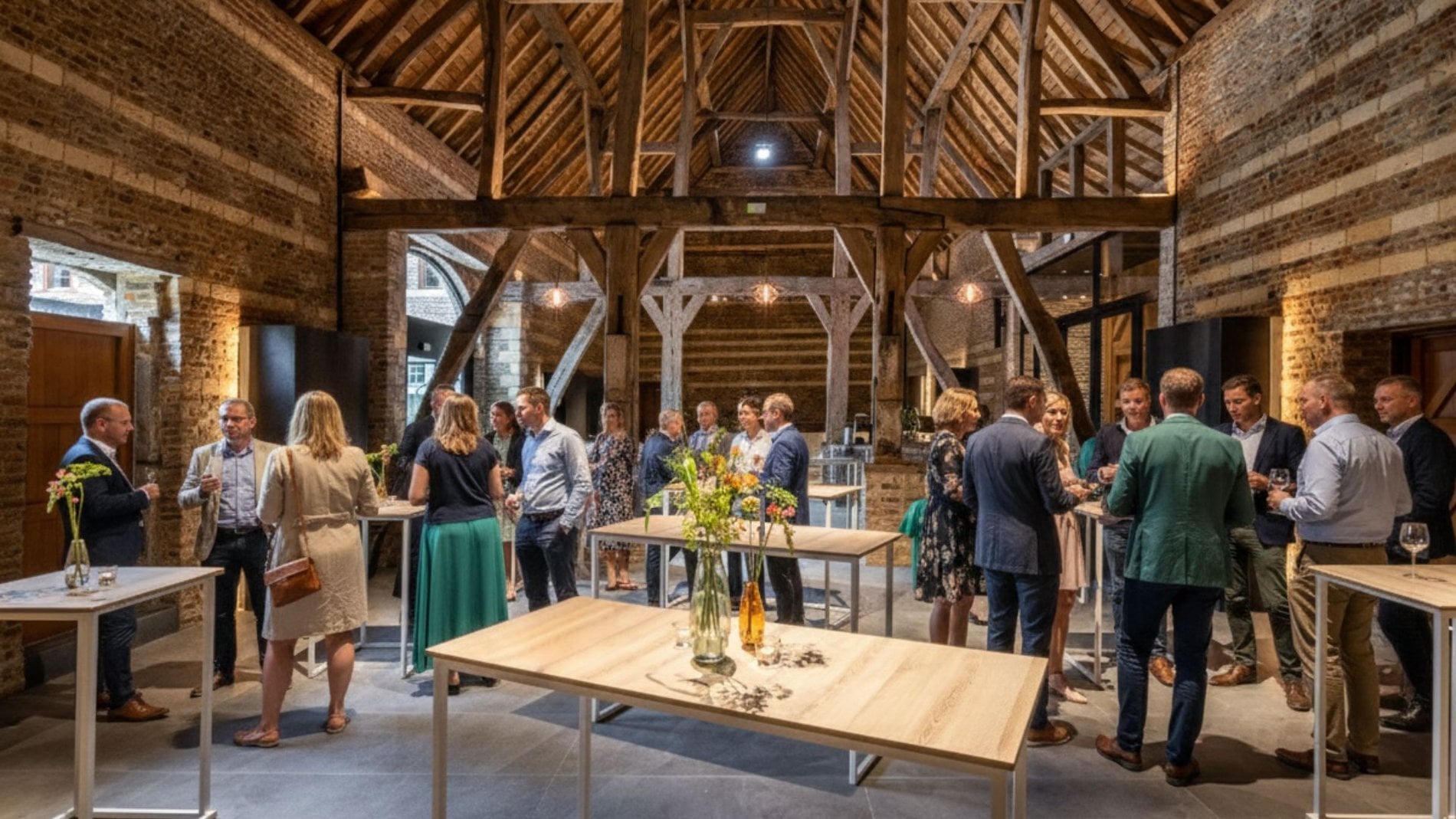 Spacious meeting room under exposed beams at Martin's Rentmeesterij in Bilzen.