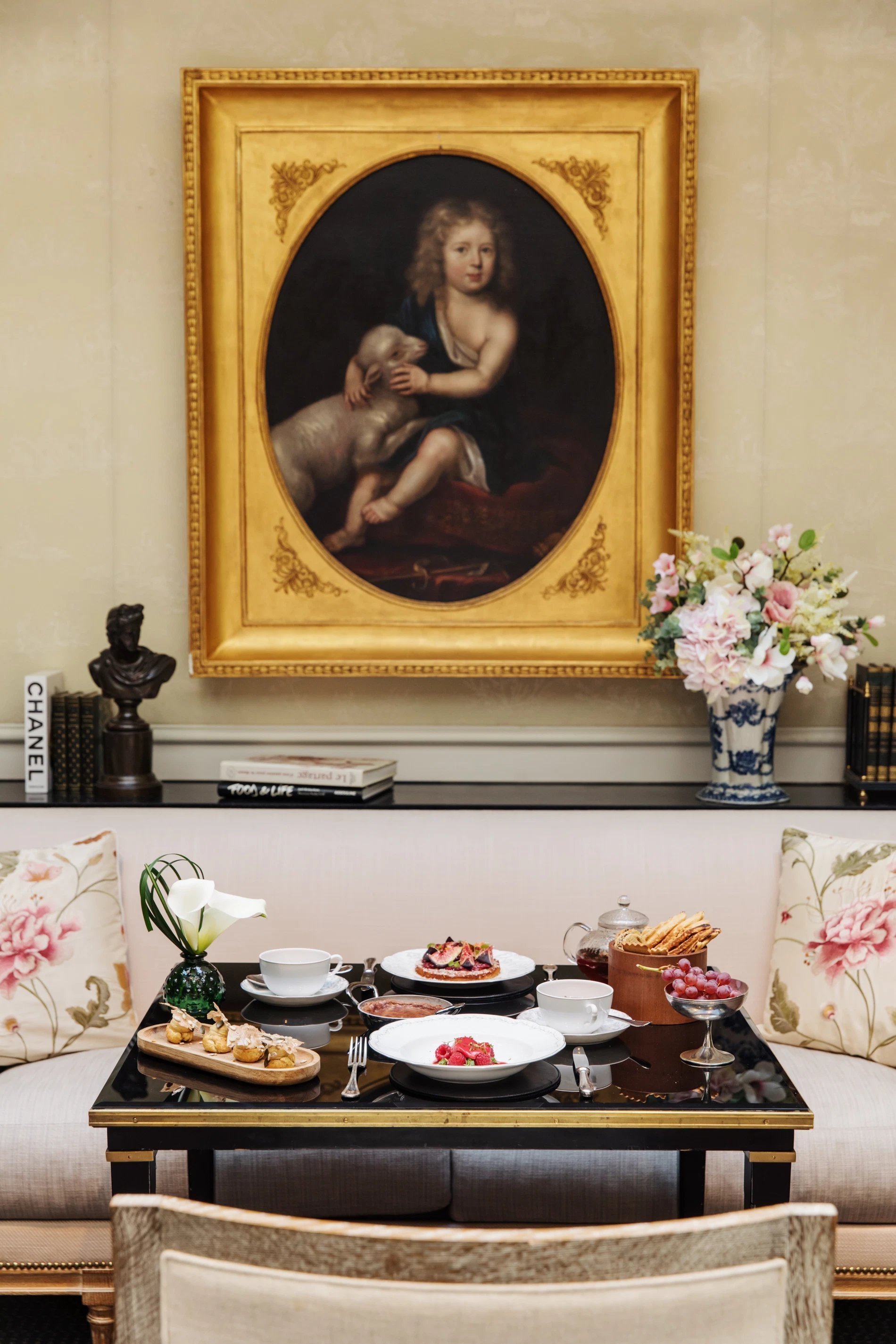 Table dressée pour un goûter à la française dans le salon feutré de l’Hôtel San Régis, sous le regard d’un portrait classique.