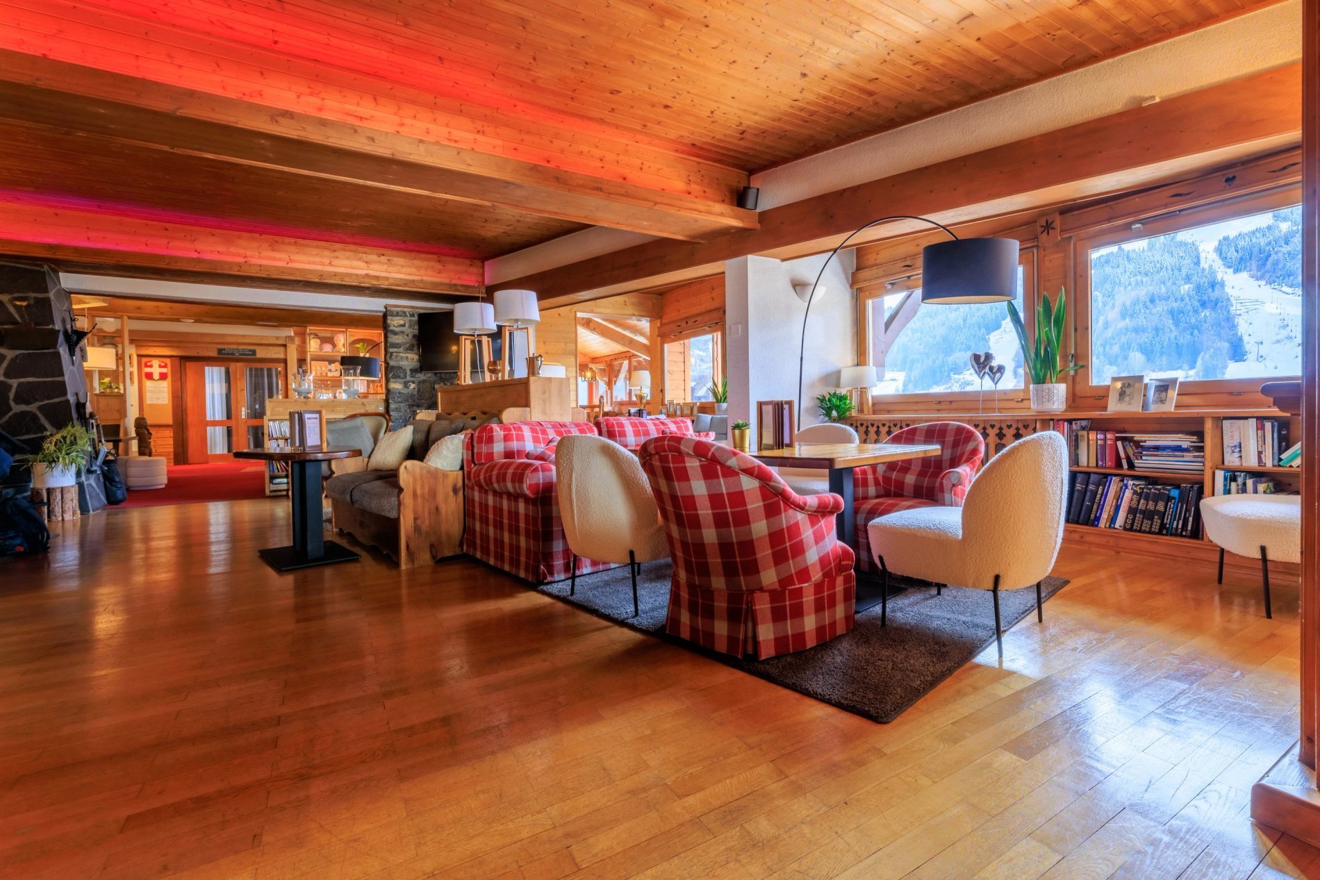 Salon chaleureux avec cheminée à l'hôtel Le Dahu, ambiance montagne authentique