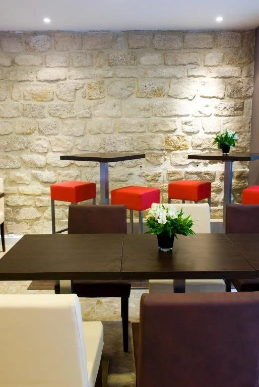 Salle de petit-déjeuner au Timhotel, avec murs en pierre