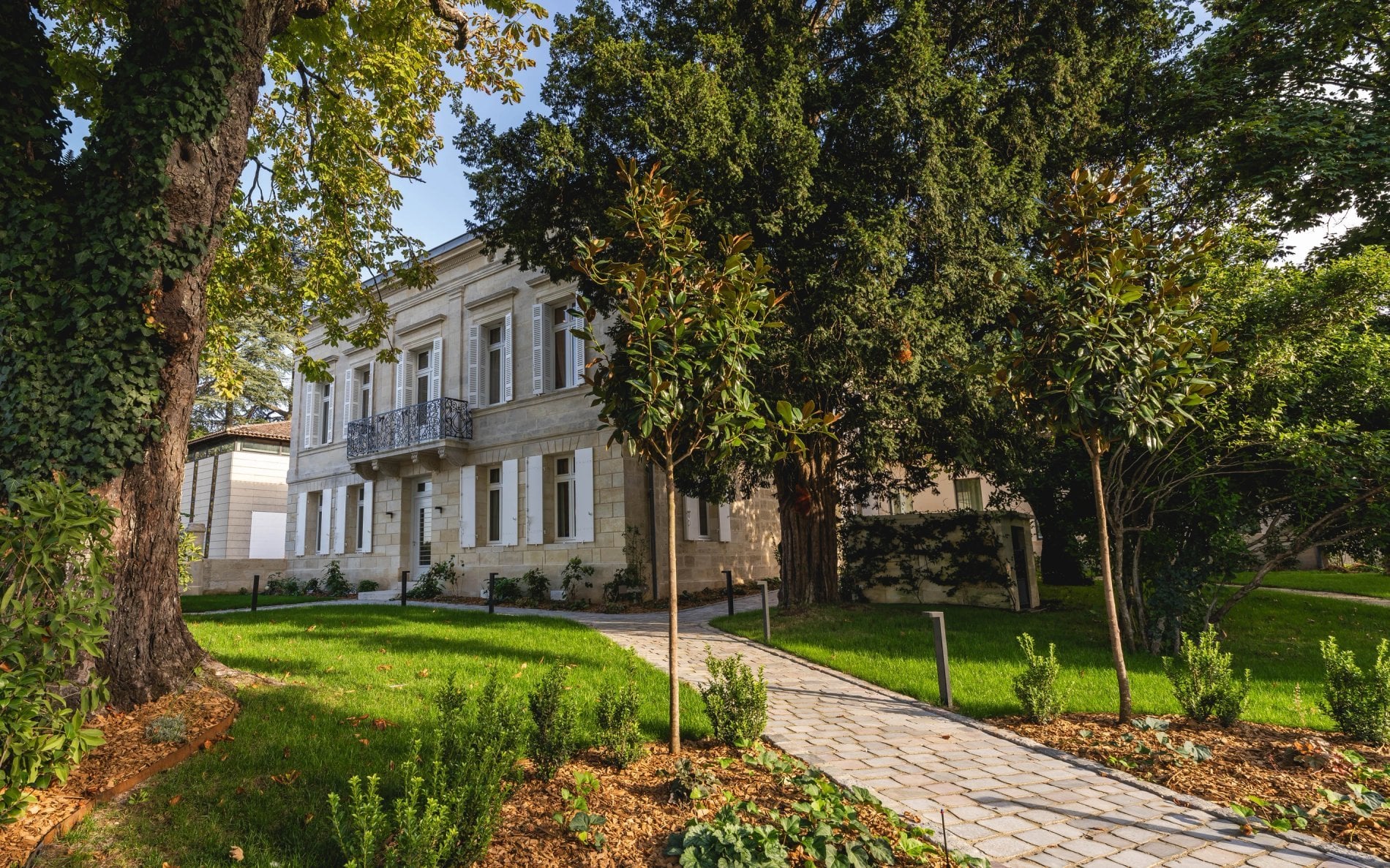 Façade et jardin arboré de La Villa des Vignes à Saint-Émilion