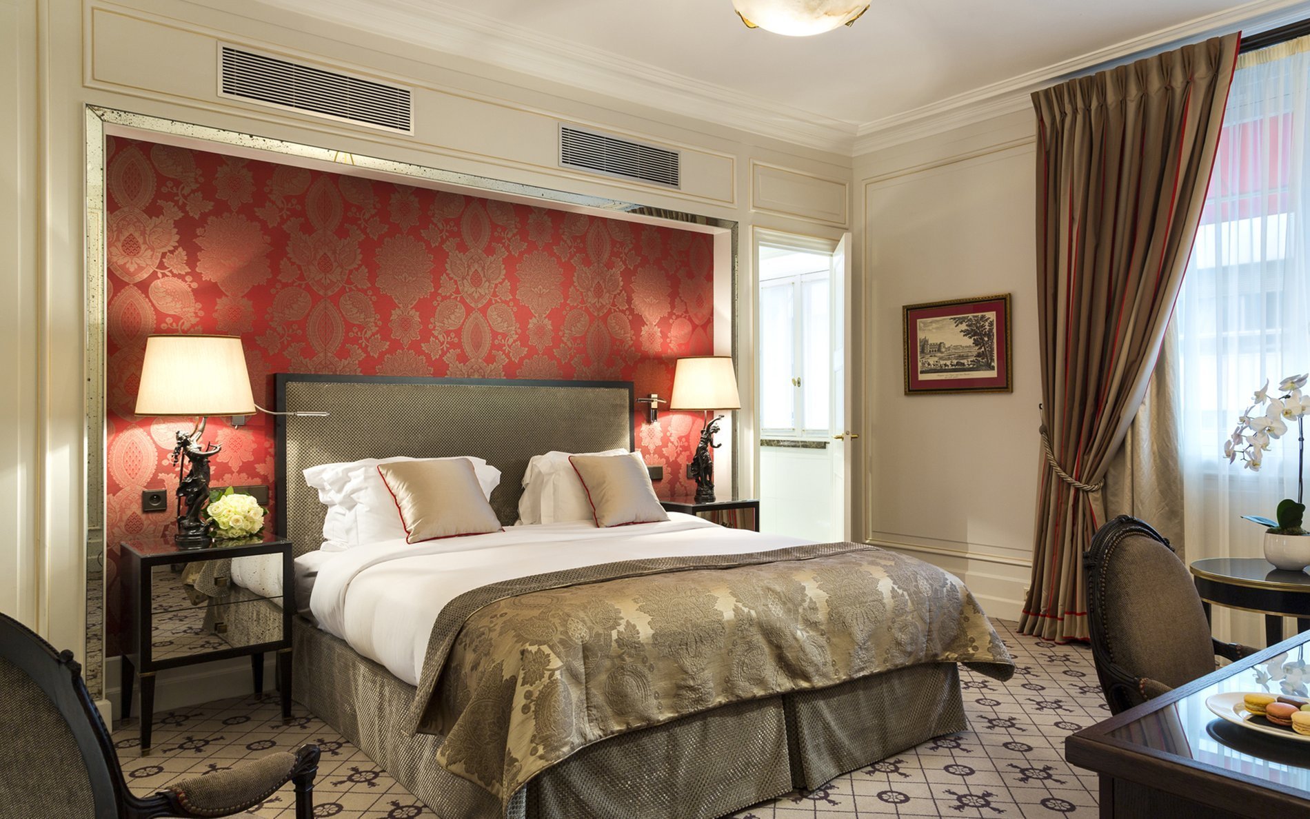 Chambre Deluxe avec avec murs rouges damassés à l’Hôtel San Régis, ambiance élégante et raffinée.