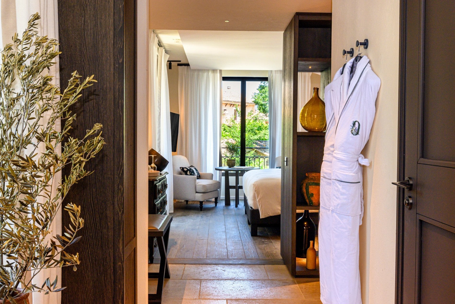 Vue sur une chambre avec peignoir suspendu et lumière naturelle à L’Isle de Leos.