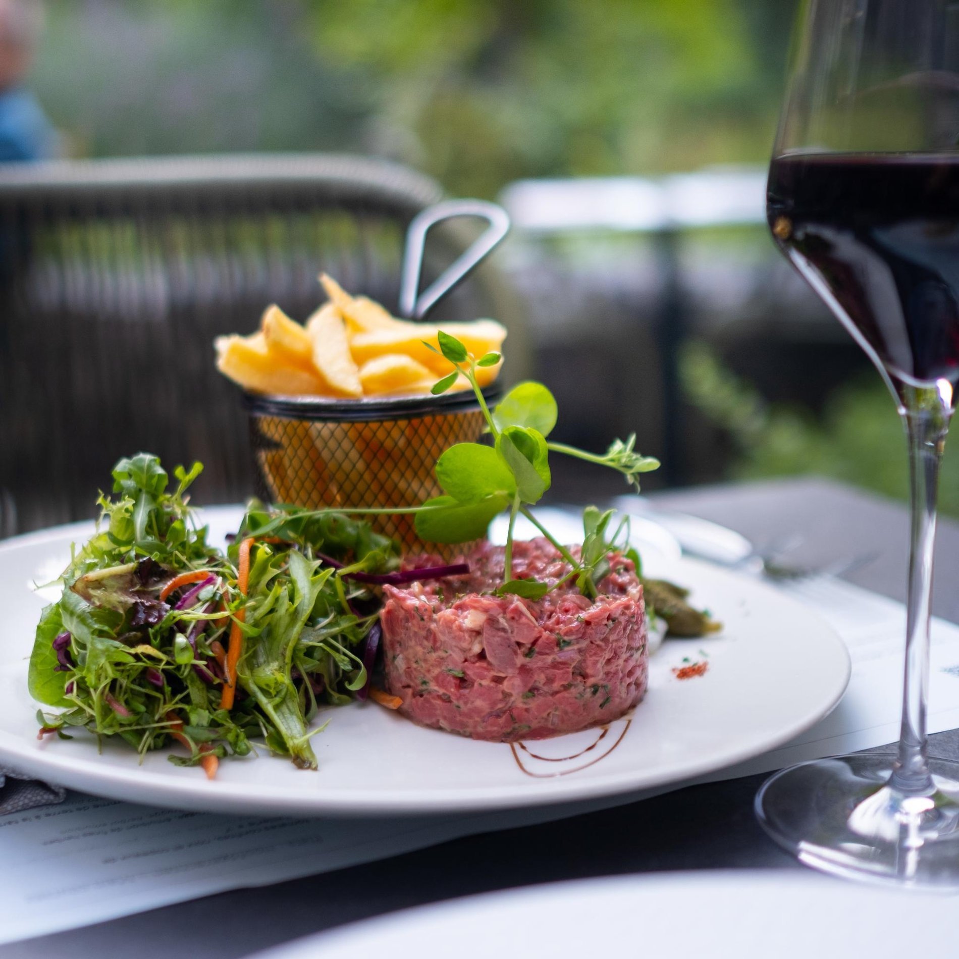 Steak Tartar mit Pommes und Salat serviert im B'Comme Restaurant.