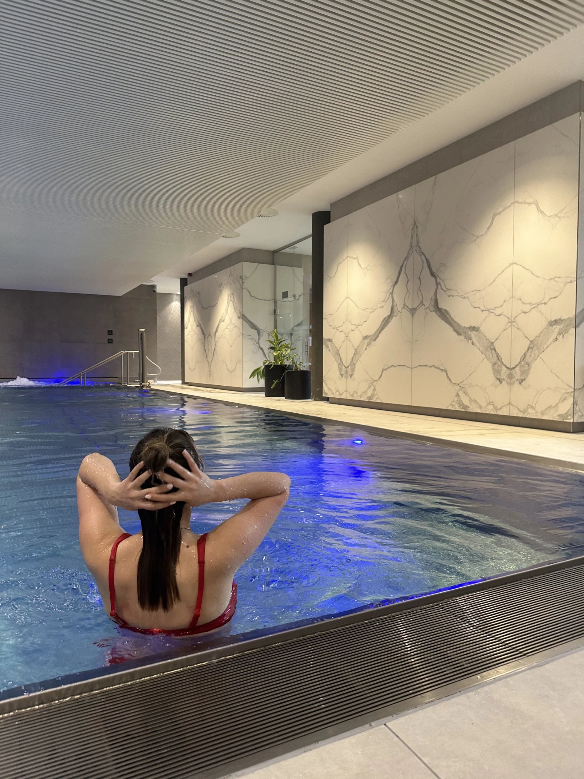 Woman enjoying a heated pool at a spa in Belgium.