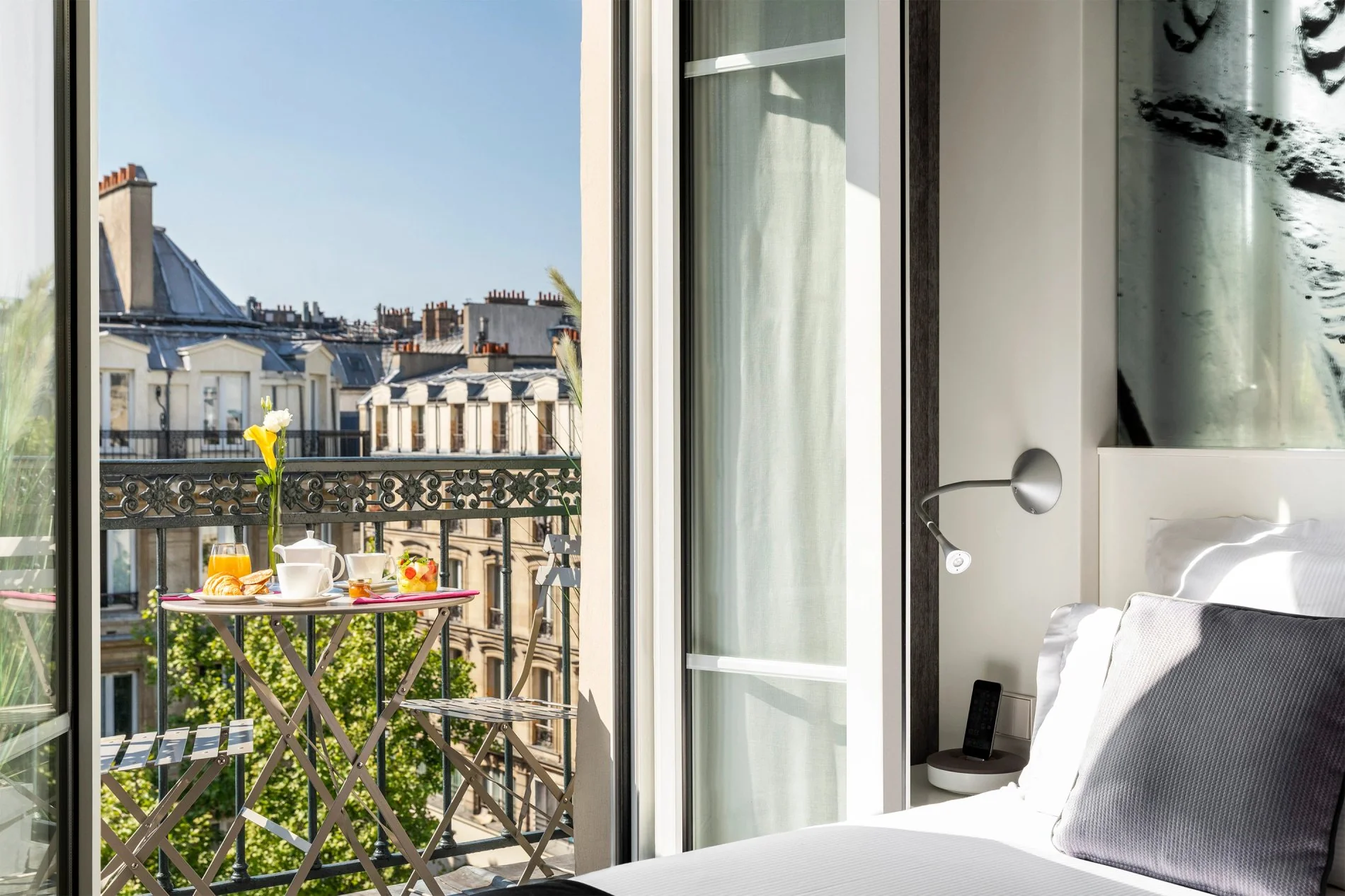 Balcony offering a view of Paris rooftops from the Marais Grands Boulevards Hotel, a 4-star establishment.