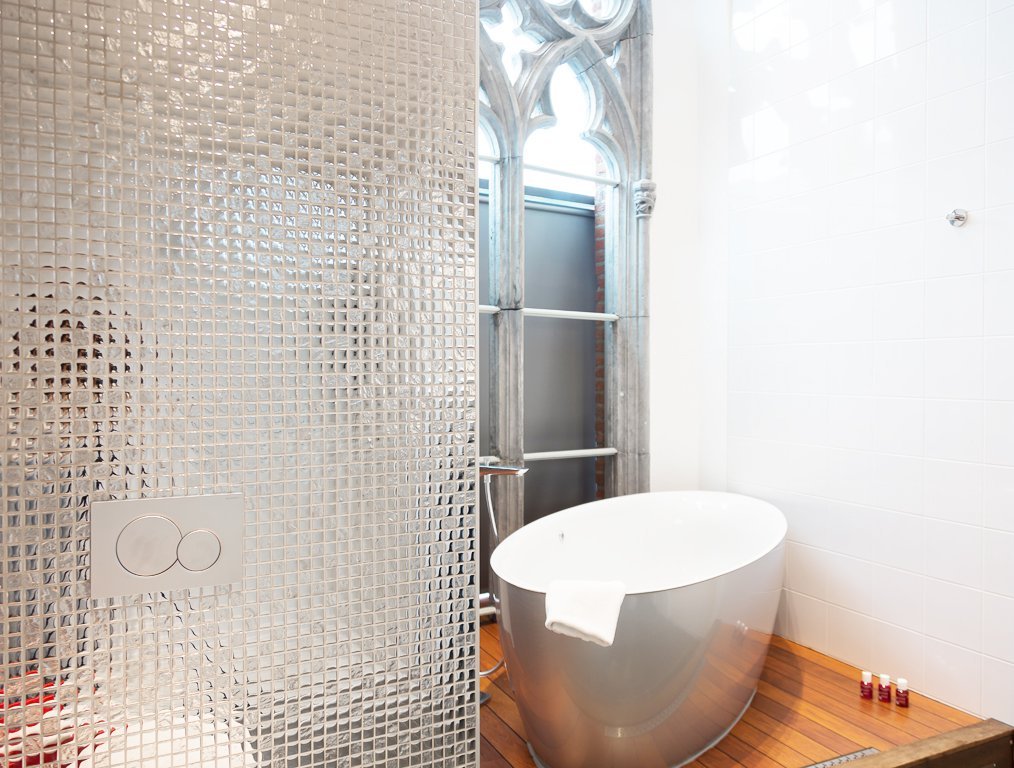 Modernes Badezimmer mit Badewanne und Mosaikfliesen.