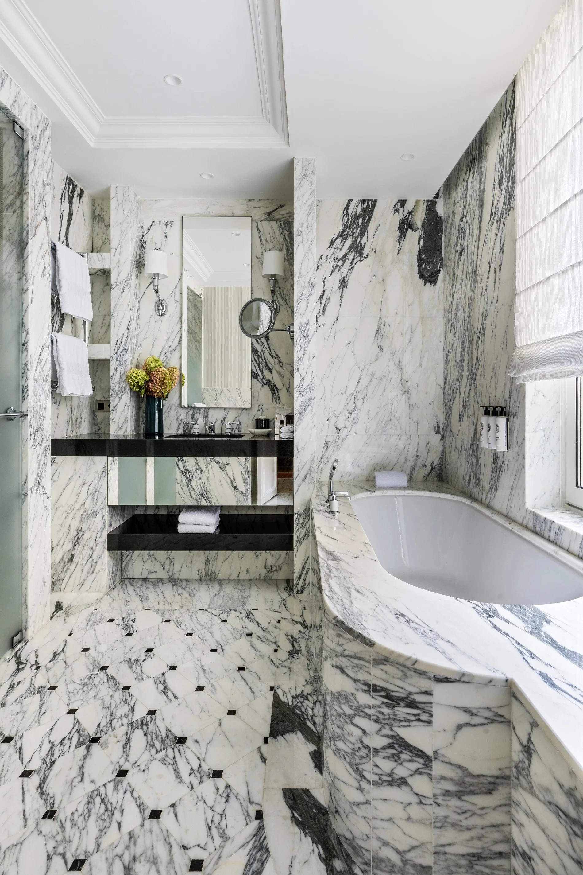 Salle de bain en marbre avec baignoire dans une Junior Suite à l’Hôtel San Régis, cadre élégant à Paris 8.