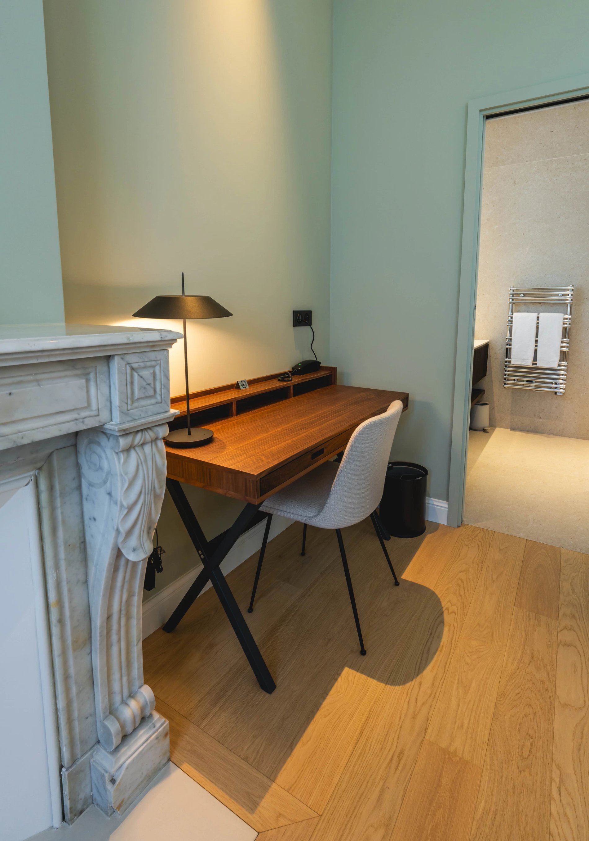 Bureau en bois et cheminée dans la Chambre Essentielle de la Villa des Vignes