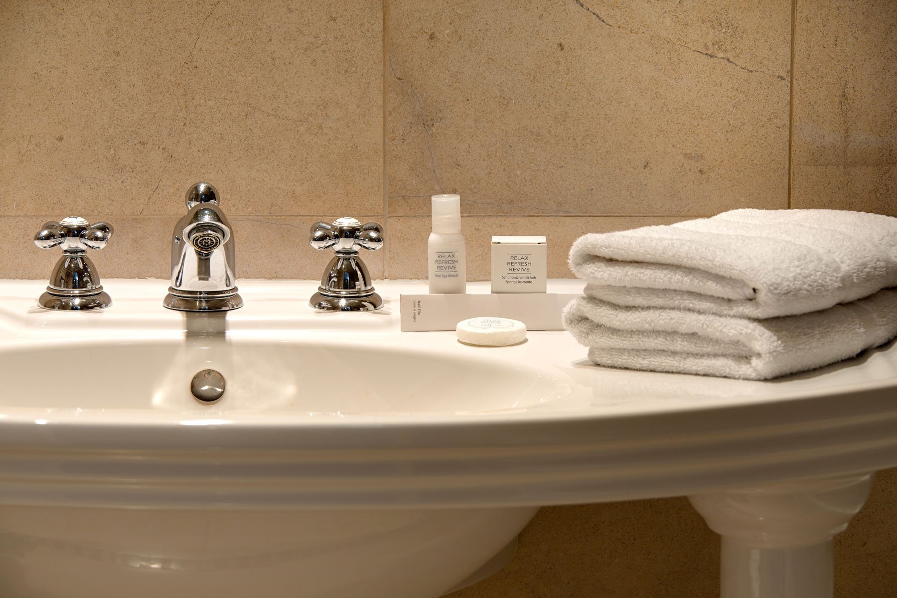 Neat bathroom with retro washbasin and bathroom linen at the Art Déco Euralille hotel
