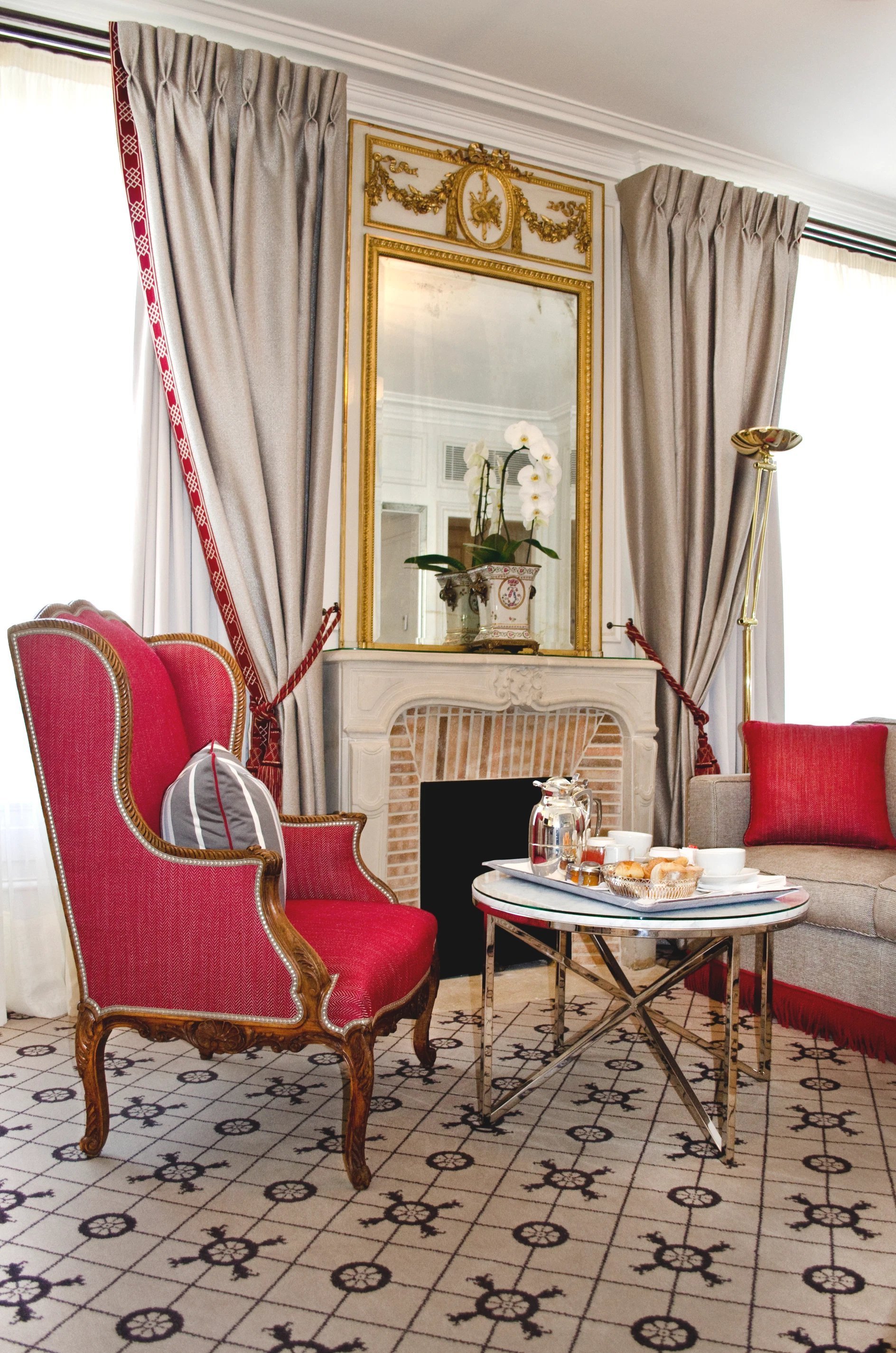 Salon élégant d’une chambre Prestige à l’Hôtel San Régis, fauteuils et cheminée dorée.
