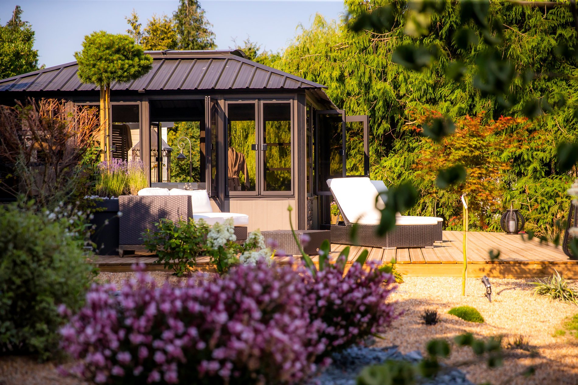 Pergola avec transats dans l'environnement verdoyant de l'Hôtel La Ramade, symbolisant un lieu de repos.