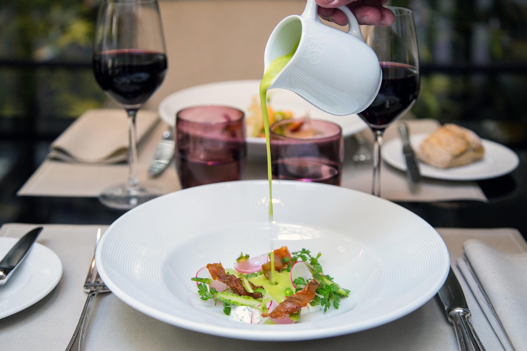 Dressage d’un velouté au restaurant Les Confidences de l’Hôtel San Régis, une adresse gastronomique au cœur du 8e à Paris.