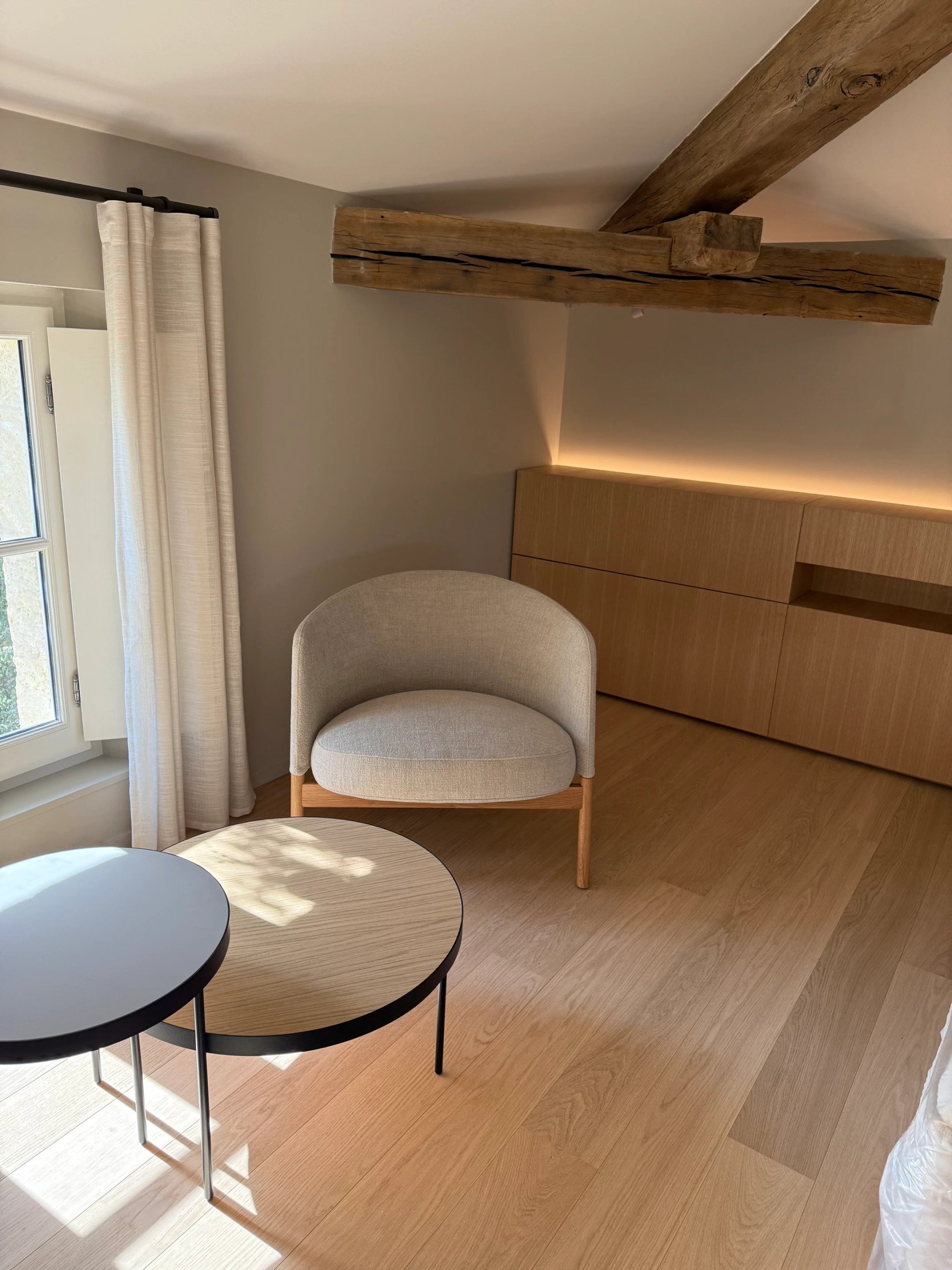 Coin salon lumineux avec poutre apparente dans la Suite Élégance de la Villa des Vignes