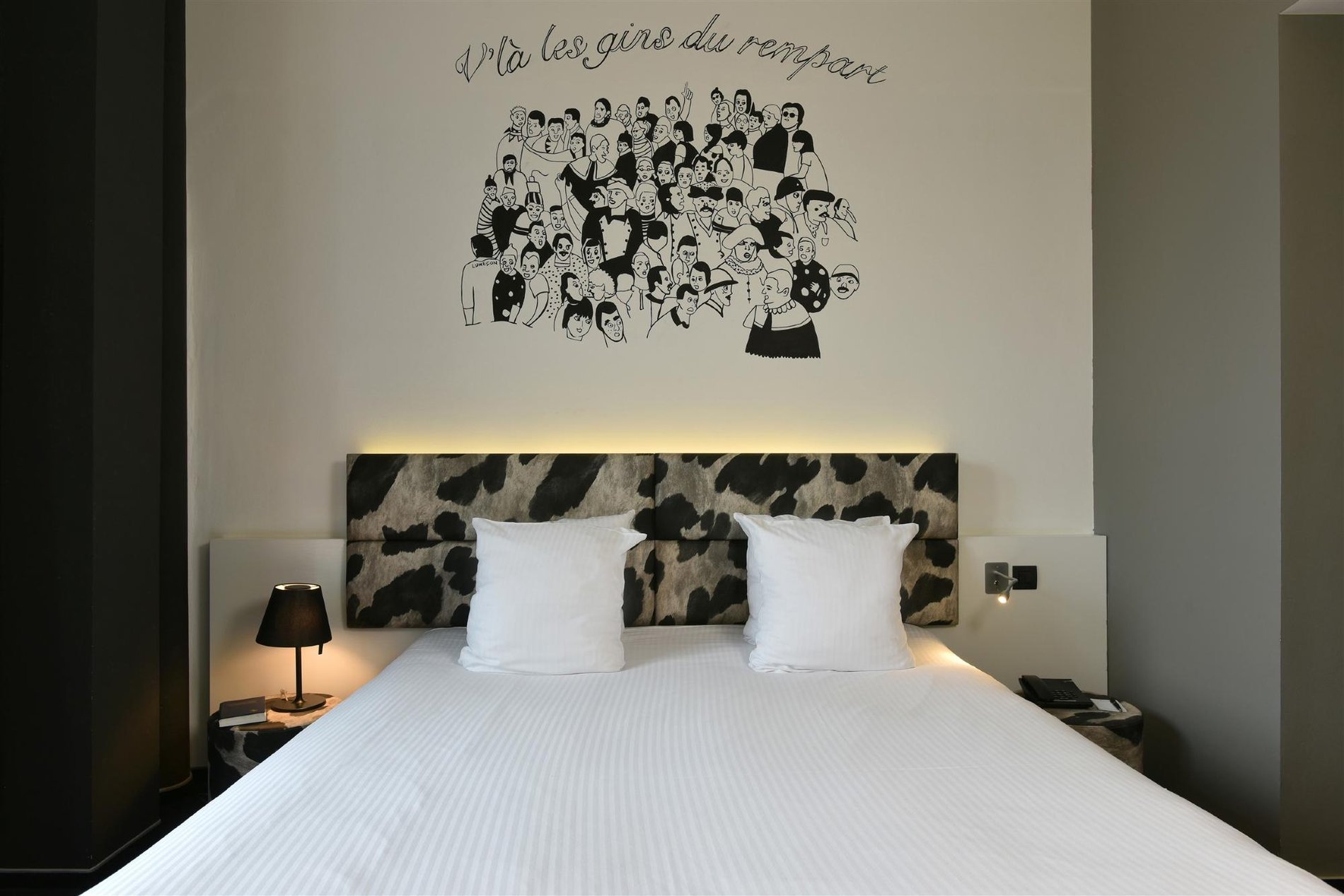 Charmantes Zimmer mit Doppelbett und Wandillustration.