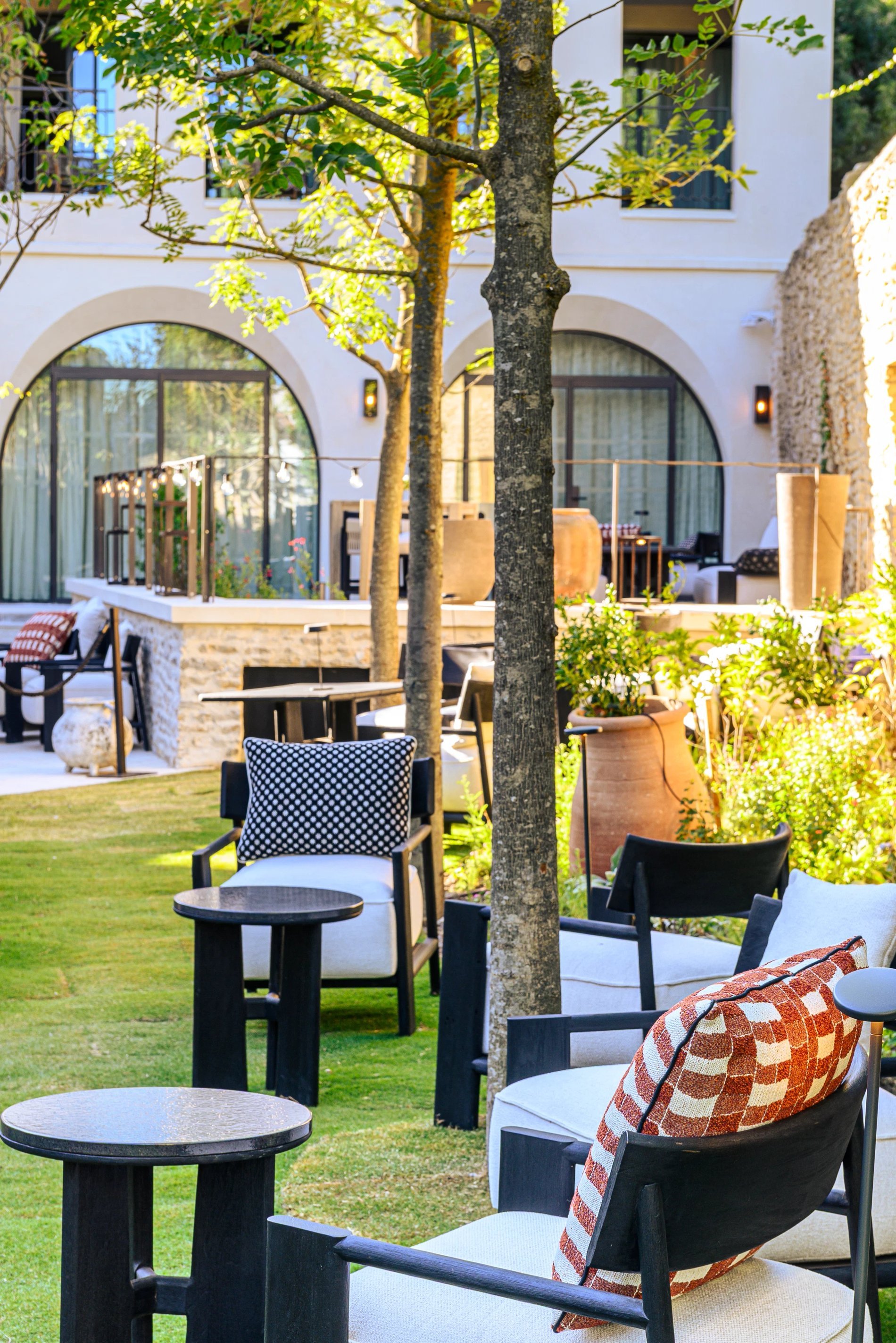 Alcôve à palabre et terrasse extérieure du bar de L’Isle de Leos, entourées de verdure