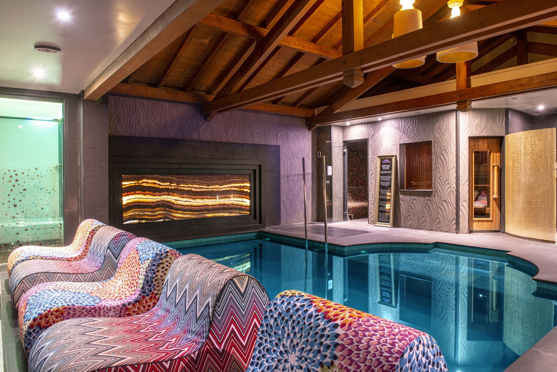 Grand bassin intérieur du spa avec éclairage d'ambiance et espace de détente, au Mont Spa Les Trésoms à Annecy.