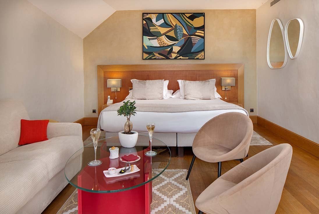 Chambre de La Côte Saint-Jacques avec lit double, fauteuils, table basse et décoration contemporaine