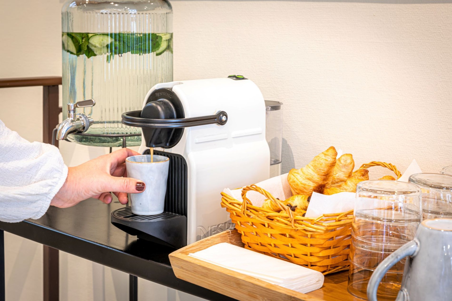 Espace café et thé en libre-service à l'Hôtel Ariane Montparnasse avec boissons chaudes et eau fraîche à disposition tout au long de la journée