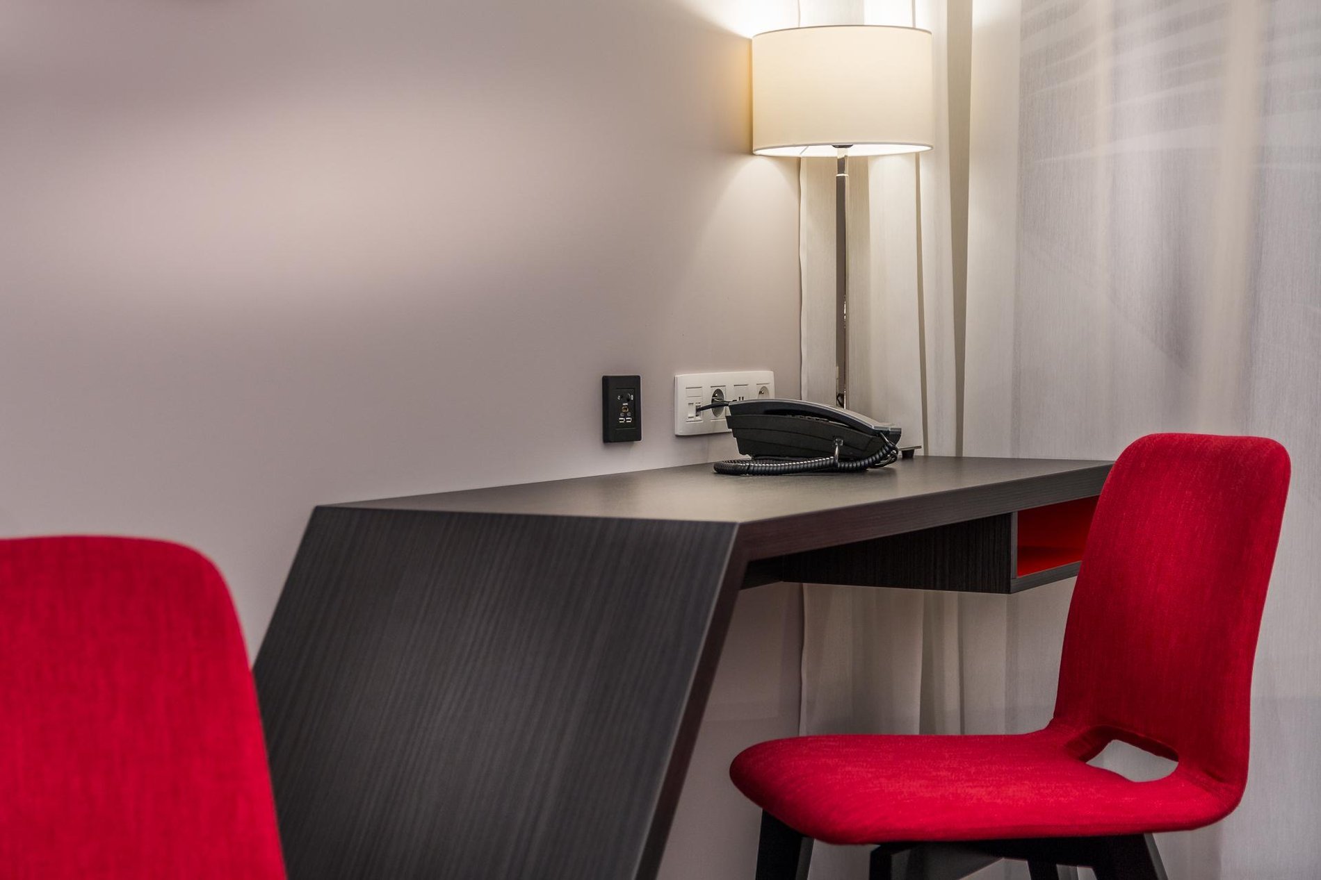 Desk area in a Charming Double room at Martin's Red with a red chair and desk lamp.