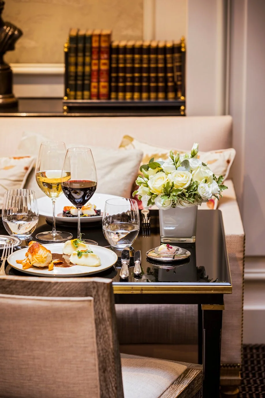 Refined gourmet dish served at Les Confidences restaurant, Hôtel San Régis, in Paris 8, with wine glasses.