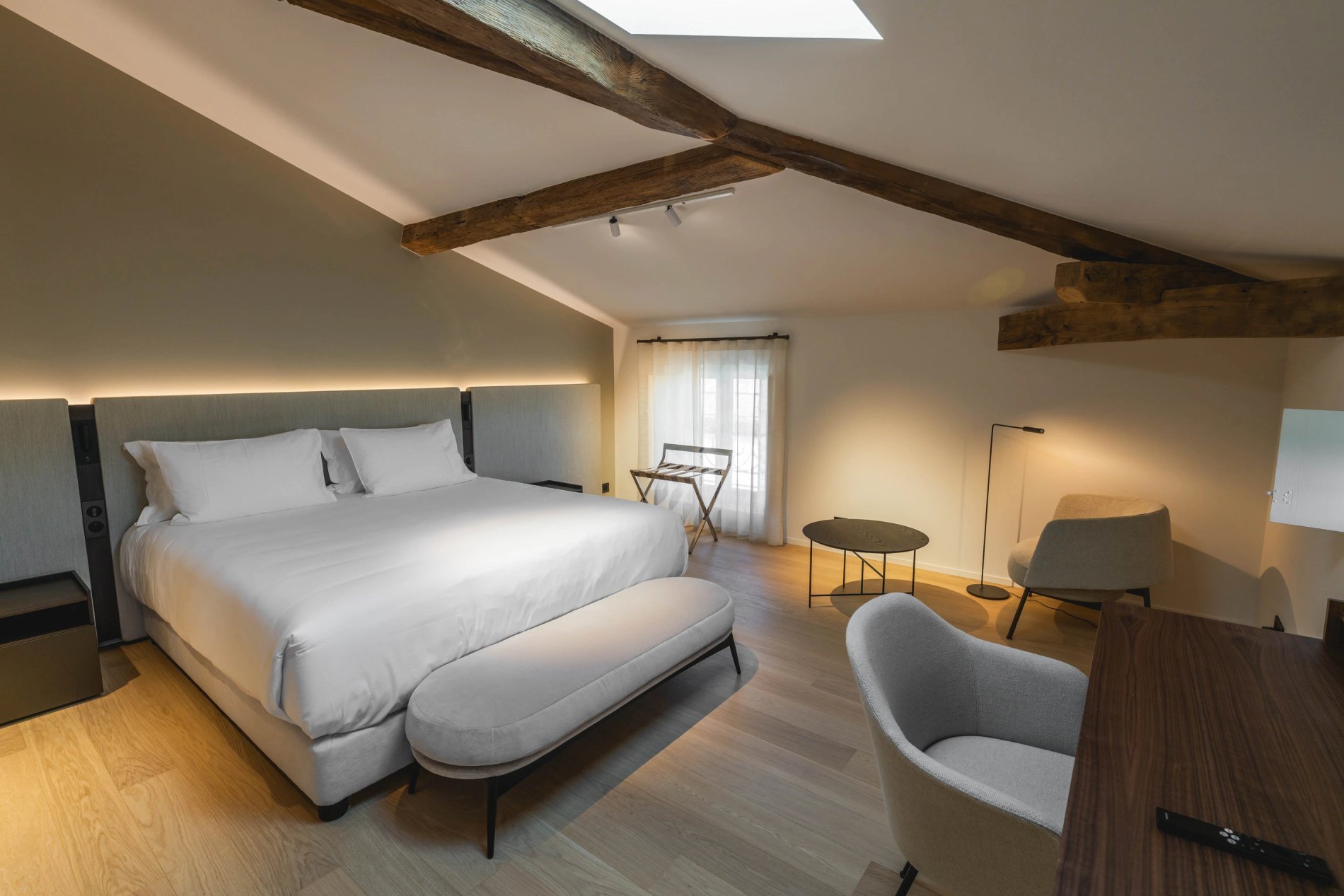 Lit double et poutres apparentes dans la Suite Prestige à la Villa des Vignes à Saint-Émilion