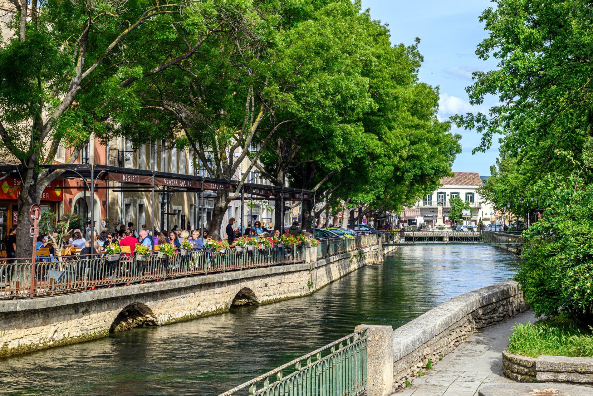 Vue pittoresque du canal bordé de restaurants à L’Isle-sur-la-Sorgue