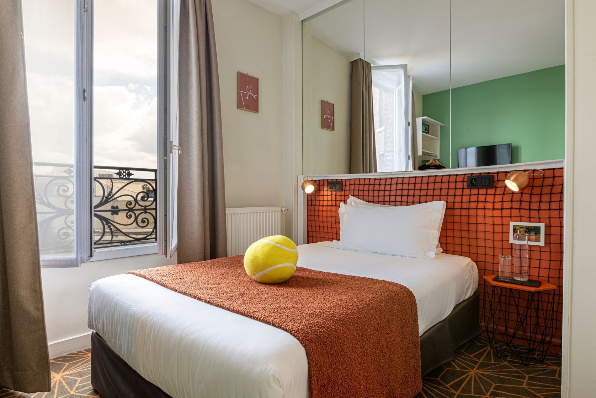 Chambre Single de l’Hôtel Olympic à Boulogne-Billancourt avec lit confortable, décoration inspirée du tennis et lumière naturelle.