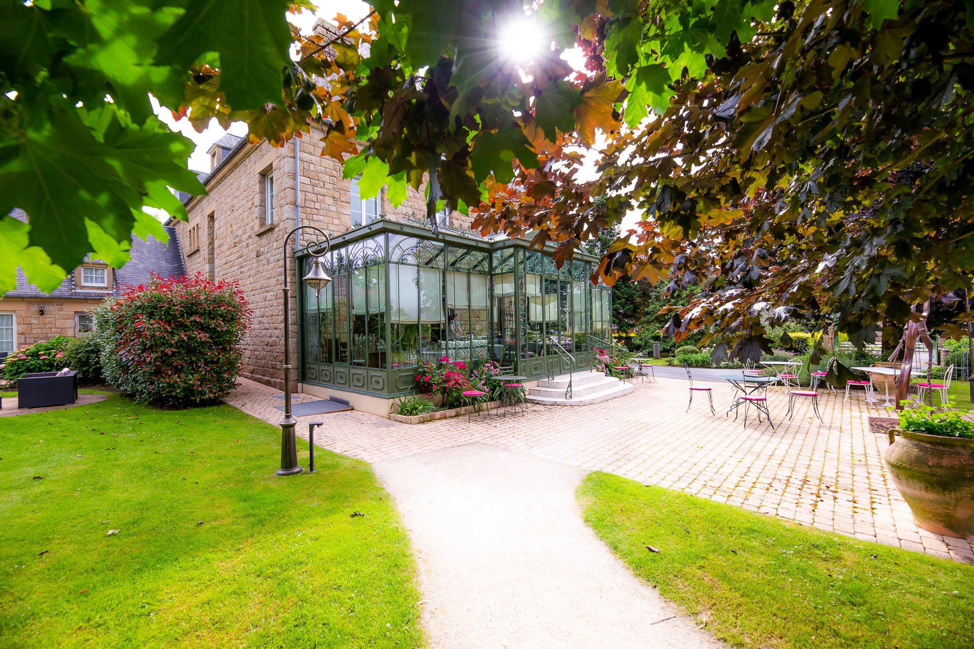 Extensive garden of Hotel La Ramade with the conservatory, symbolizing a lush and peaceful setting for guests.