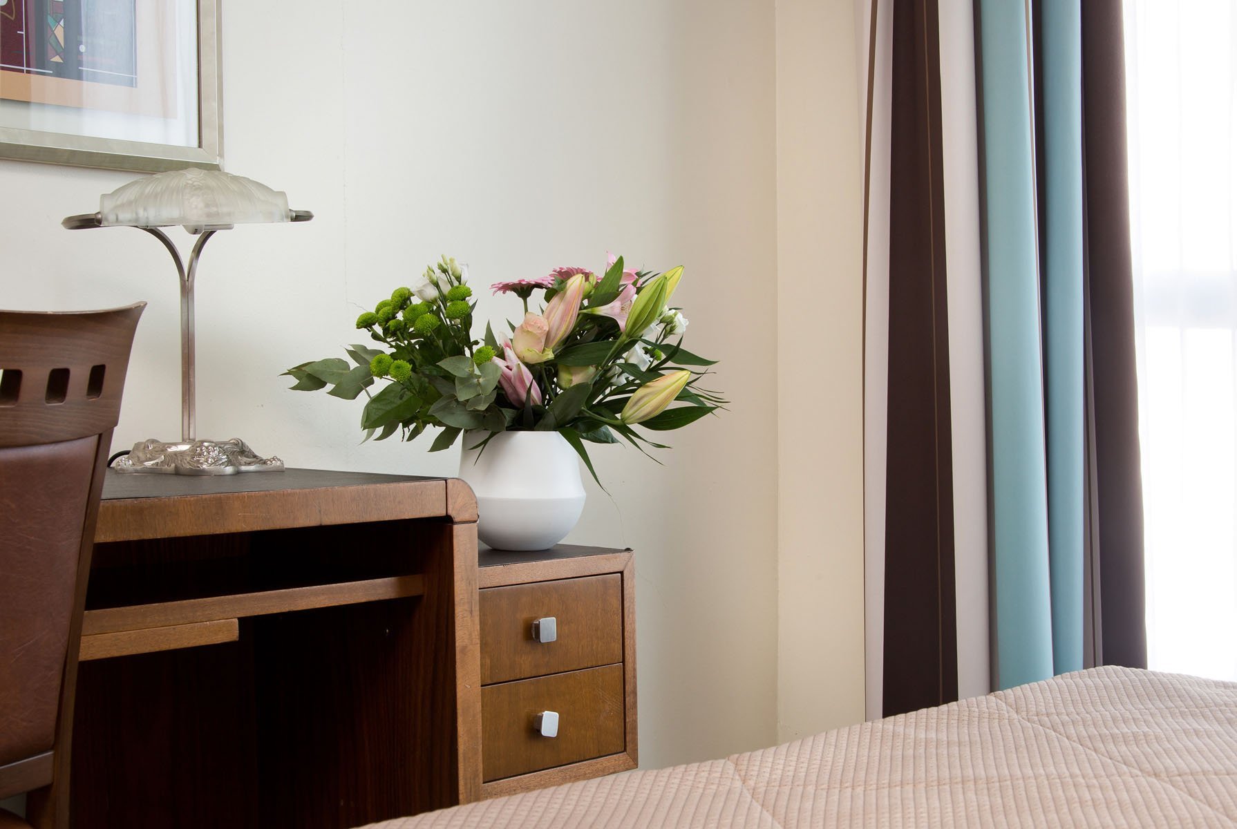 Desk area with bouquet of flowers in an elegant room at the Art Deco Euralille hotel