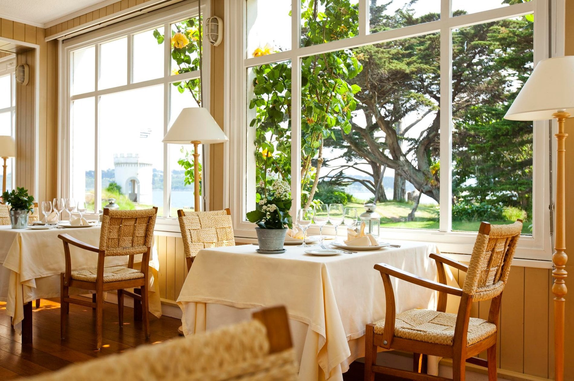 Salle du restaurant du Grand Hôtel des Bains baignée de lumière naturelle, ambiance chaleureuse et vue sur le jardin