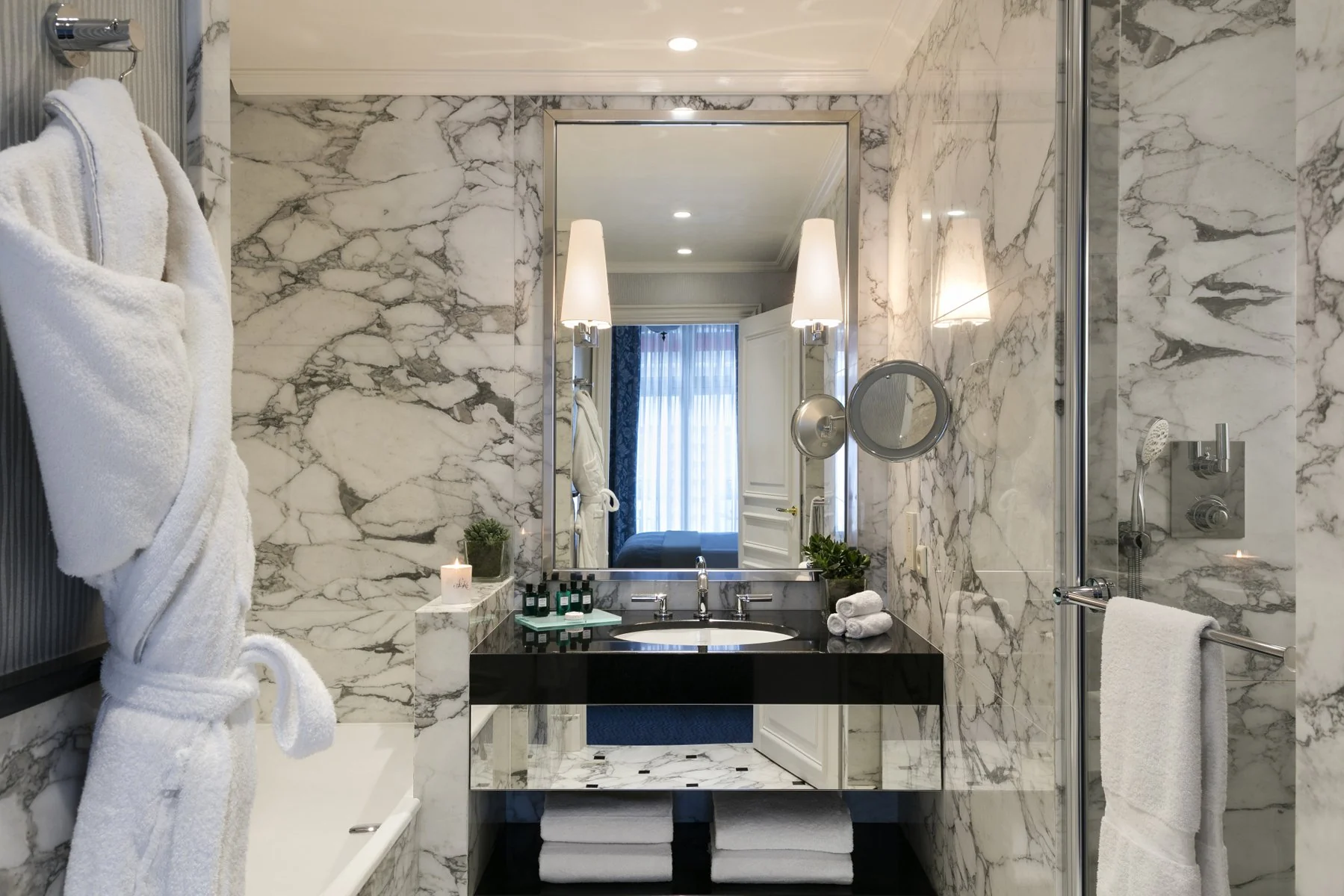 Salle de bain en marbre blanc dans une Junior Suite de l’Hôtel San Régis Paris, avec douche à l’italienne.